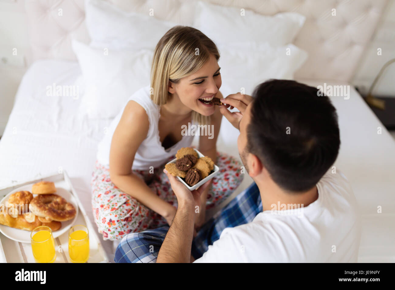 Romantische junges Paar mit Frühstück im Bett Stockfoto
