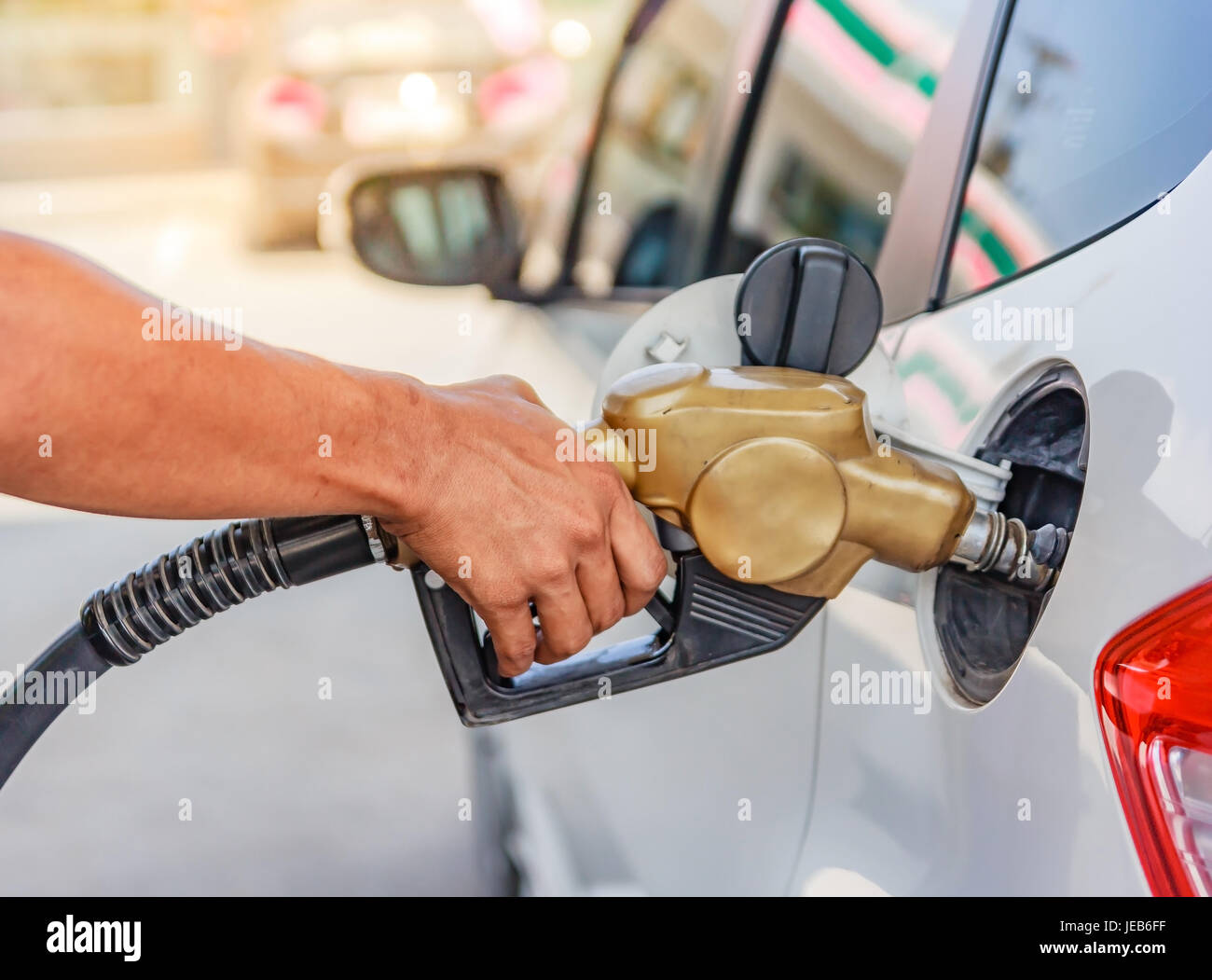 Hand des Autos mit Kraftstoff an der Tankstelle Befüllen Stockfoto