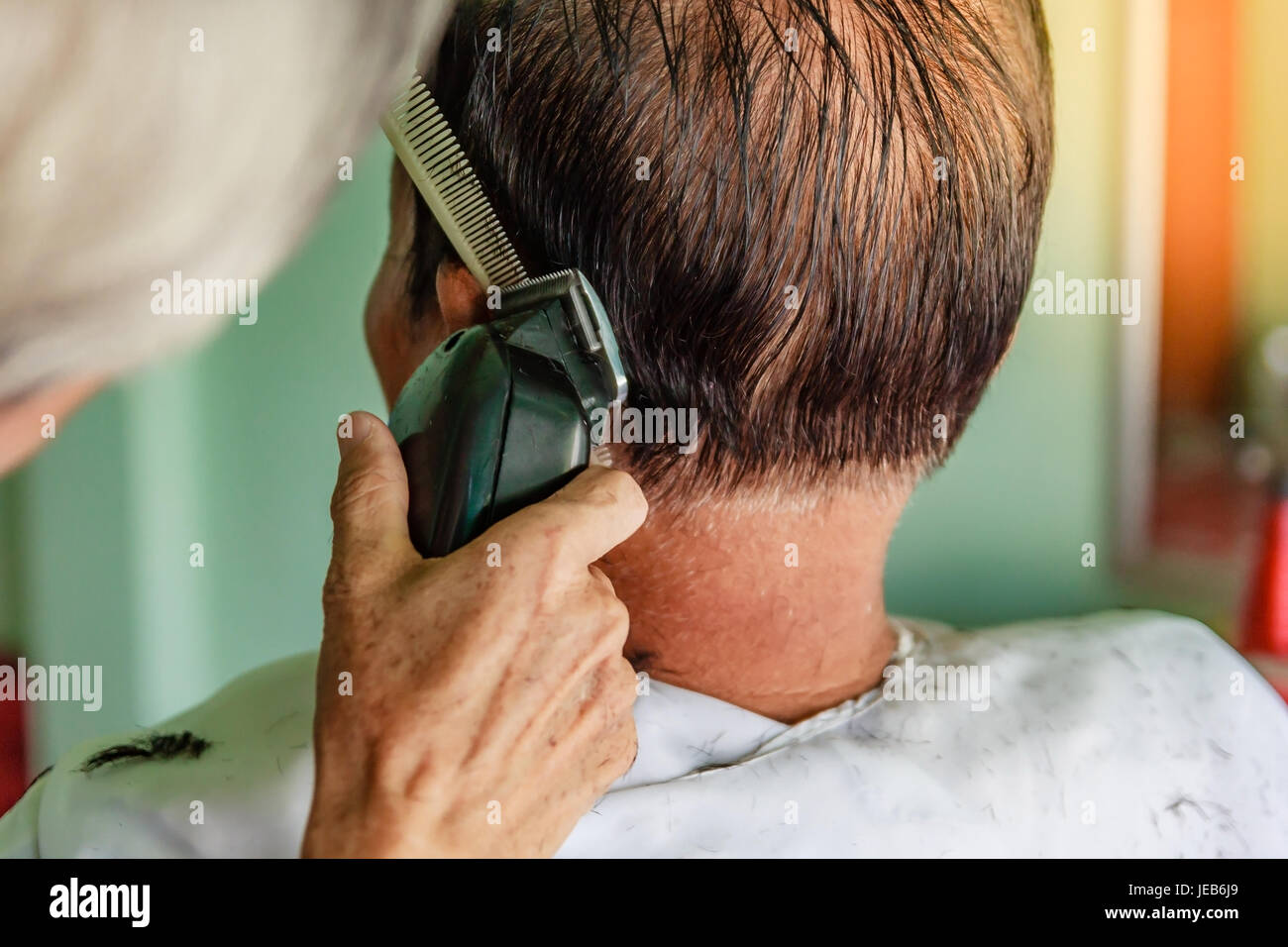 Haar-Stylist schneiden senior asiatischen Mannes graue Haare Stockfoto