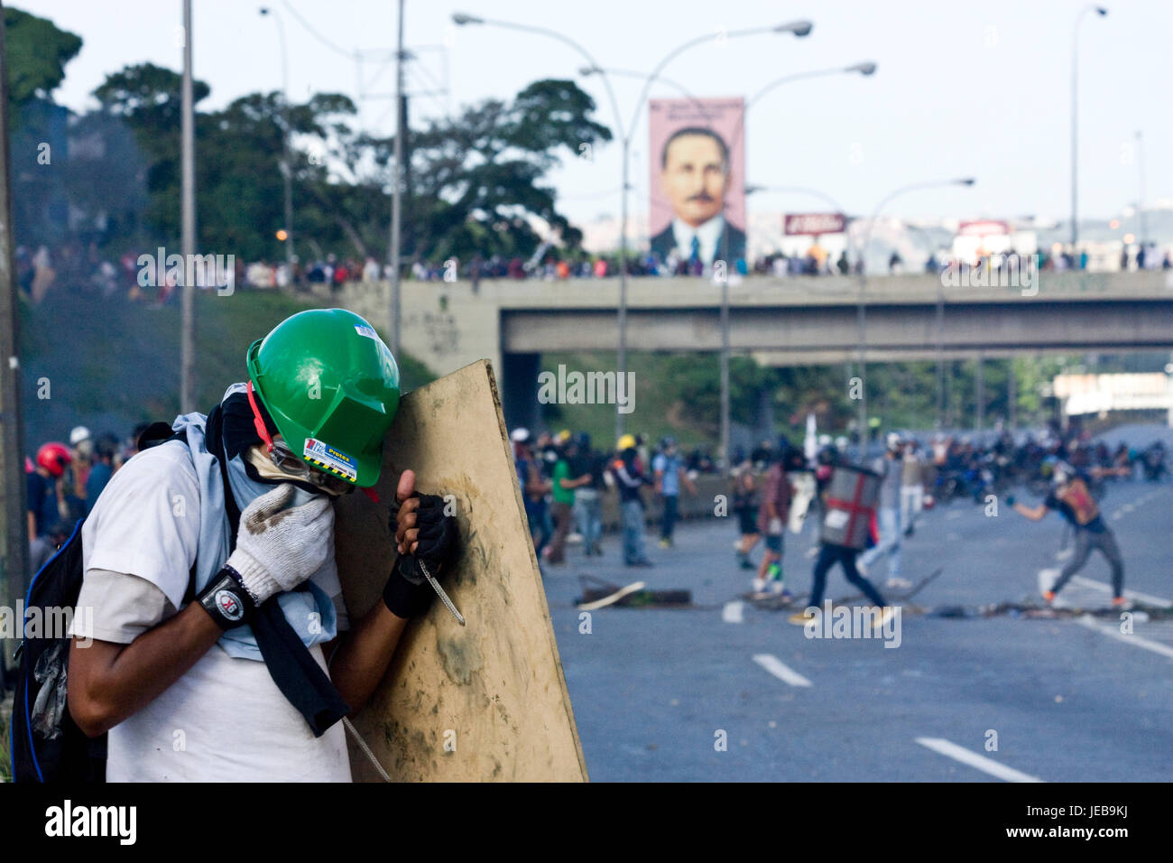 Ein Demonstrator betroffen von sauber Tränengas sein Gesicht während eines heftigen Protest auf einer Landstraße gegen Präsident Maduro. Stockfoto