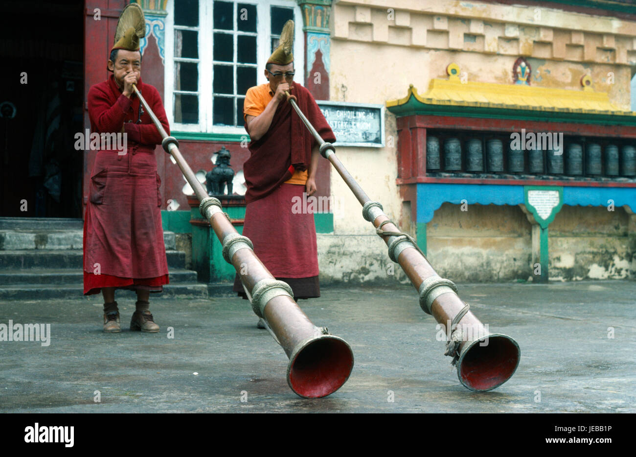 Indien, Westbengalen, Ghum, zwei gelbe Sekte buddhistische Mönche im Choling Kloster in der Nähe von Darjeeling spielen lange Hörner. Stockfoto