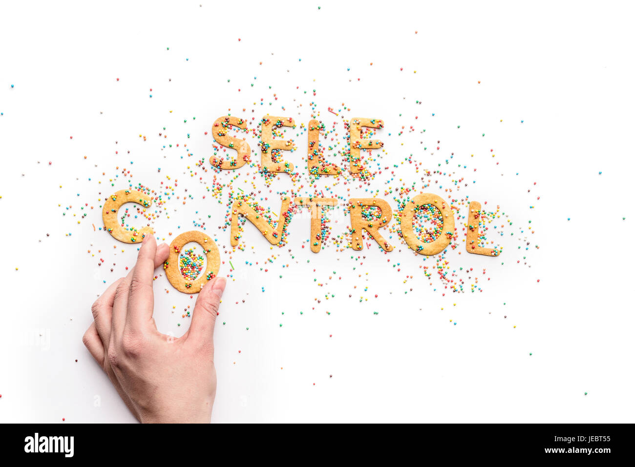 Draufsicht der Selbstkontrolle Schriftzug aus Süßigkeiten und Hand mit Brief, gesundes Wohnkonzept gemacht Stockfoto