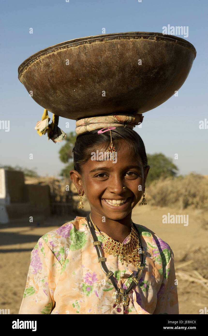 Indien, Rajasthan, Jaisalmer Region, Dorf Khuri, kleines Mädchen mit Last auf dem Kopf, Porträt, Stockfoto