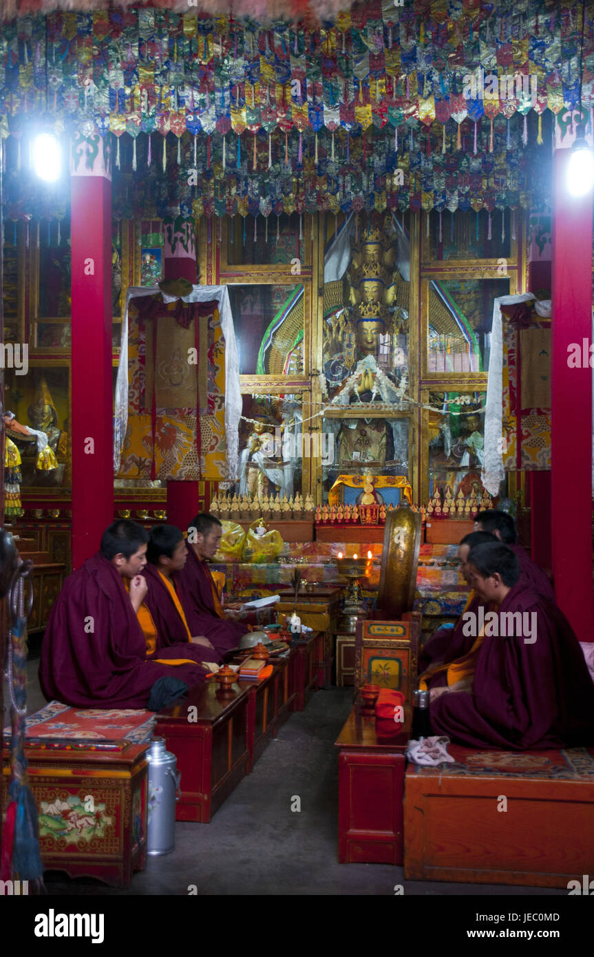 Mönche rezitieren vor einer Buddhastatue im Ramoche Tempel, Lhasa, Tibet, Asien, Stockfoto