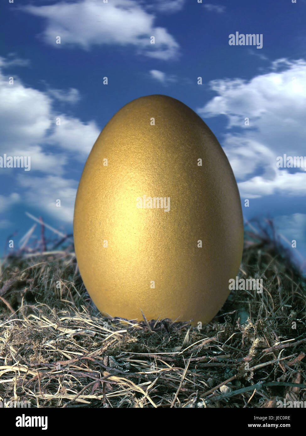 Goldenes Ei im Nest vor Wolkenhimmel, Stockfoto