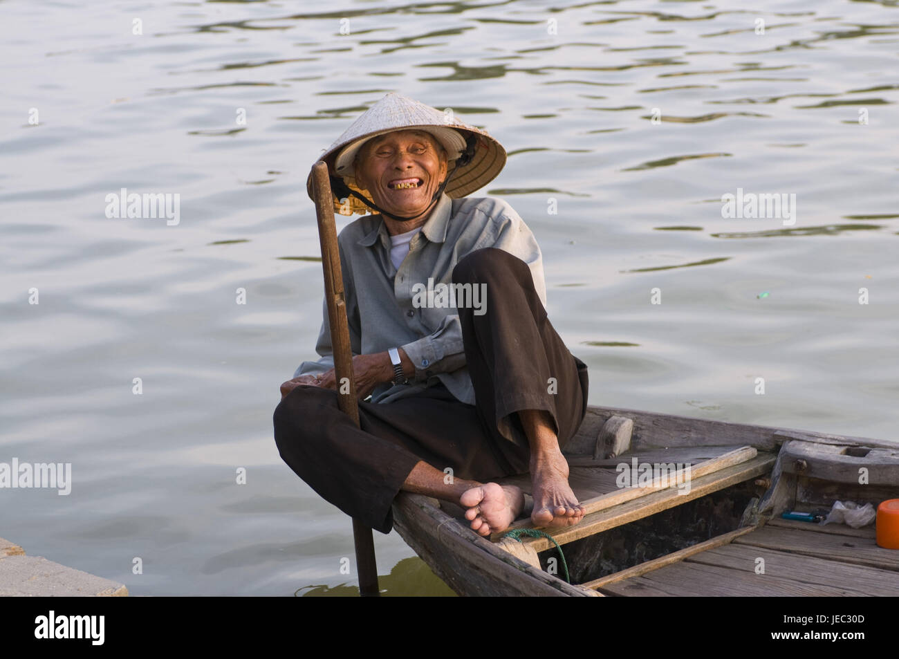 Glücklicher Alter Mann in einem Fischerboot im Hafen, Hoi an In Vietnam, Stockfoto