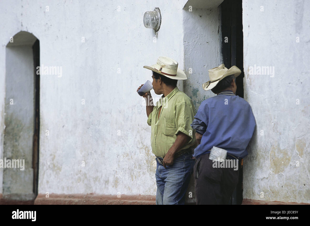 Honduras, Copan, defensive Hauswand, Cowboys, Lean, kein Model-Release, Mittelamerika, Lateinamerika, Ziel, Ort, Haus, Eingang, Menschen, Männer, Rancheros, Hüte, Stetsons, Pause, Siesta, warten, Ständer, Drink Cup, im Außenbereich Stockfoto