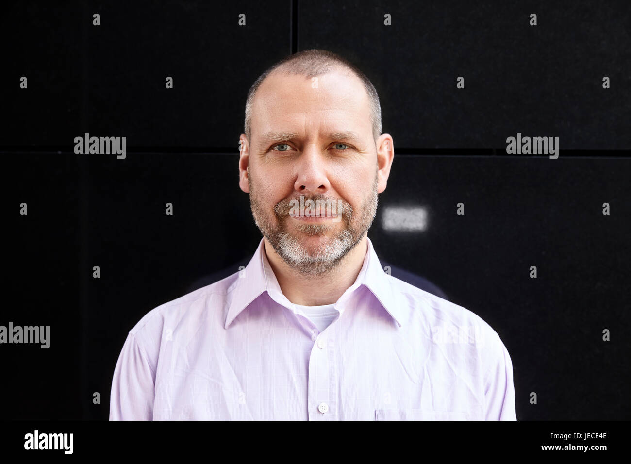 Einfache Portrait fröhlich echte Mann mittleren Alters auf schwarze Wand. Stockfoto Einfache Portrait fröhlich echte Mann mittleren Alters auf schwarze Wand. Stockfoto