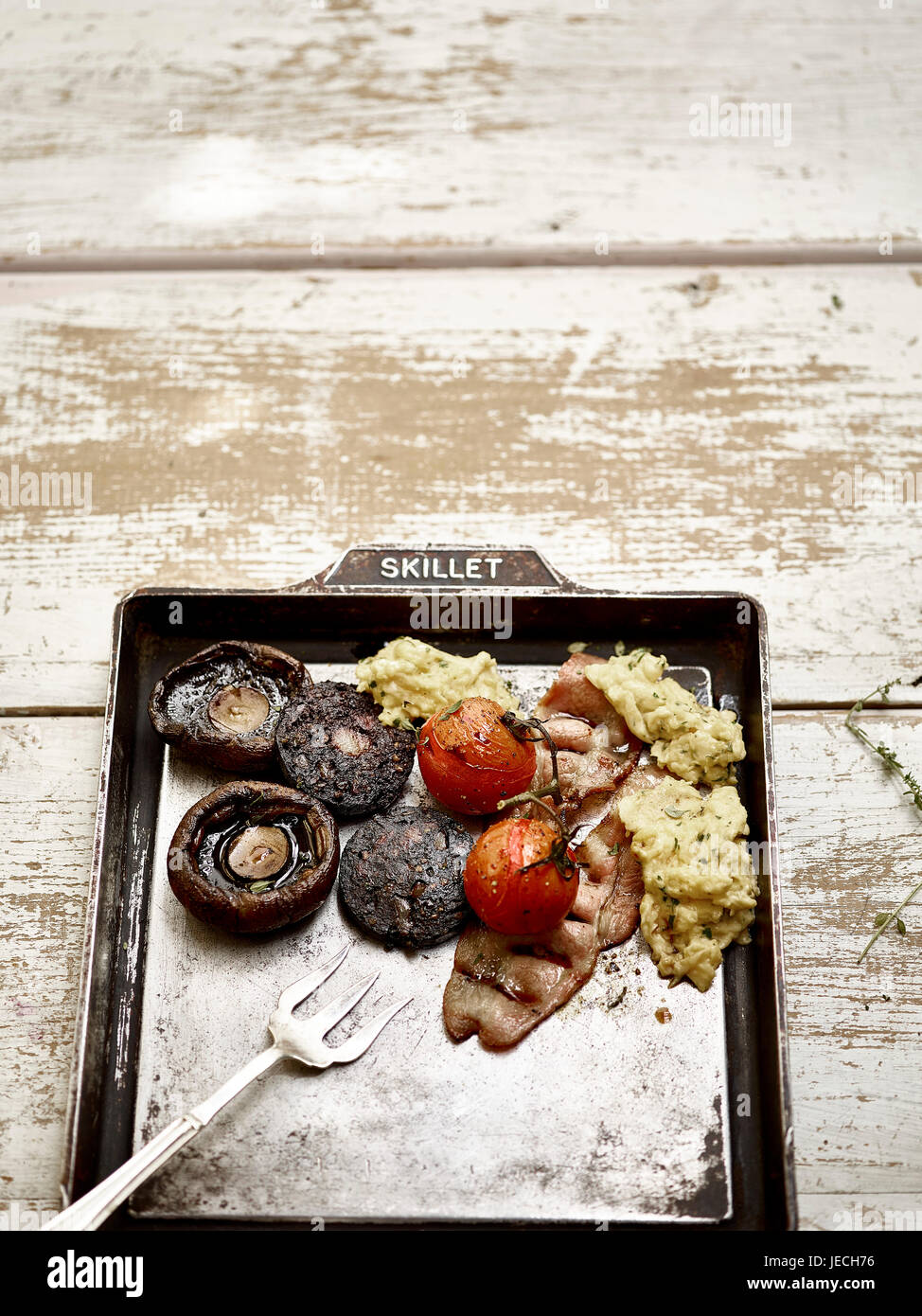 komplettes englisches Frühstück mit Blutwurst Speck Champignons und Eiern Stockfoto