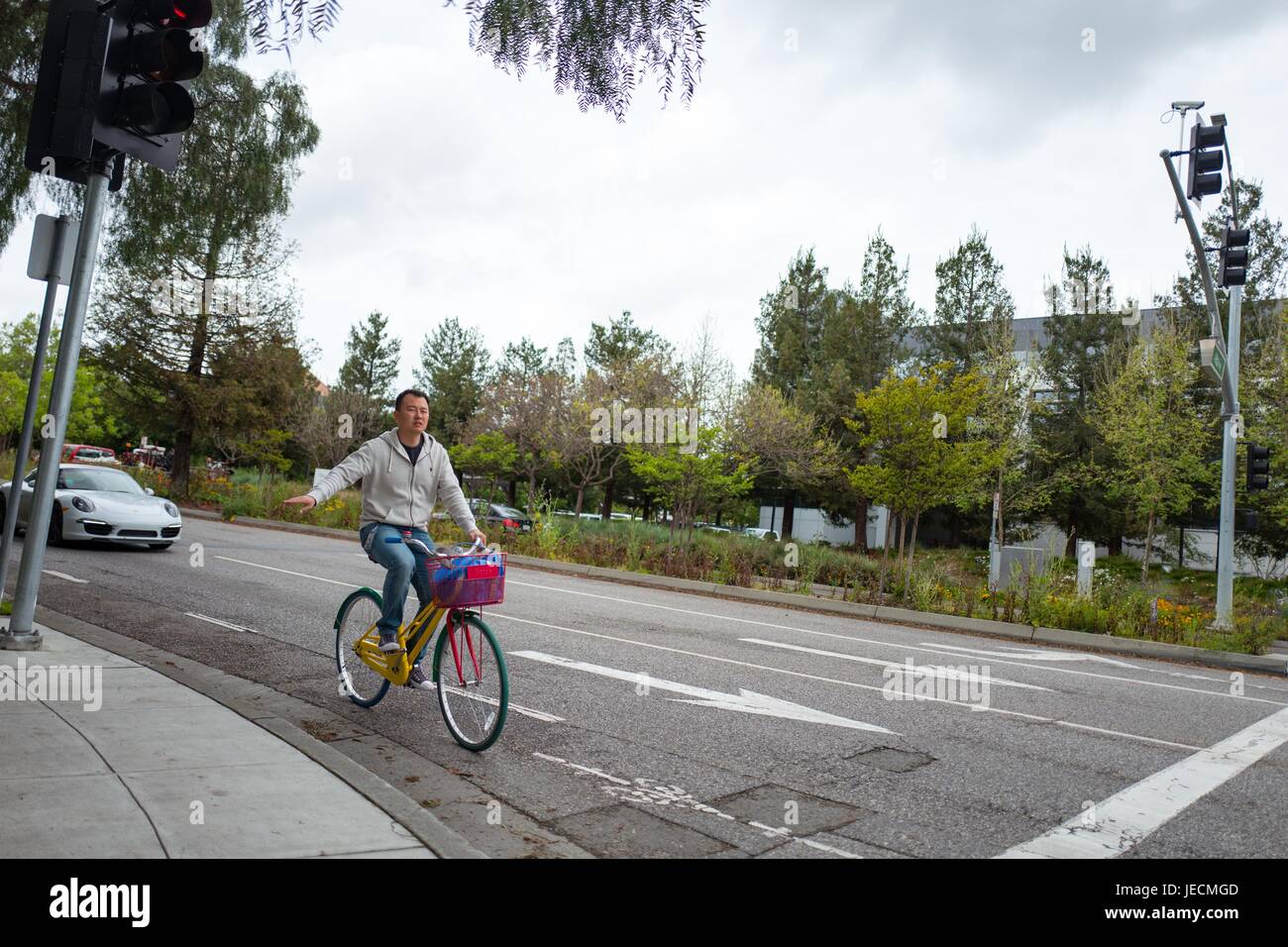 Ein Mitarbeiter von Google Inc signalisiert mit seiner Hand während der Ausführung einer Wende auf dem Google-Fahrrad, im Googleplex, Sitz der Google Inc in das Silicon Valley Stadt Mountain View, Kalifornien, 7. April 2017. Stockfoto