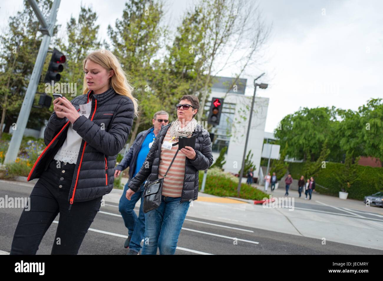 Zwei Frauen überprüfen ihre Handys beim Überqueren einer Straße im Googleplex, Sitz der Google Inc in das Silicon Valley Stadt Mountain View, Kalifornien, 7. April 2017. Vielfalt für die Anmietung ist ein wichtiges Thema im Silicon Valley, vor allem die Einbeziehung von mehr Frauen in Technik Rollen. Stockfoto