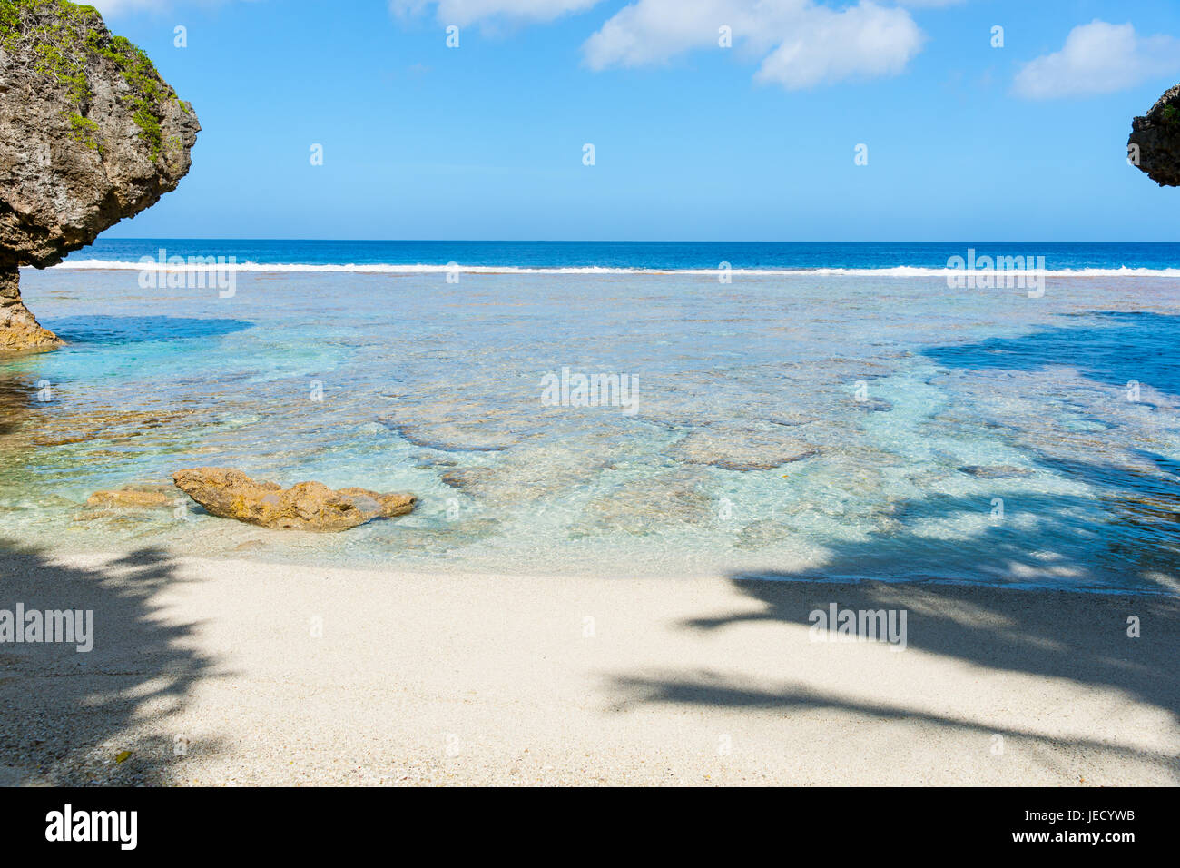 Tropischen Mustern und Farben von Korallenriff, Meer und Himmel vom Islated Strand eingerahmt von Schatten und Rock Küsten Funktionen Stockfoto
