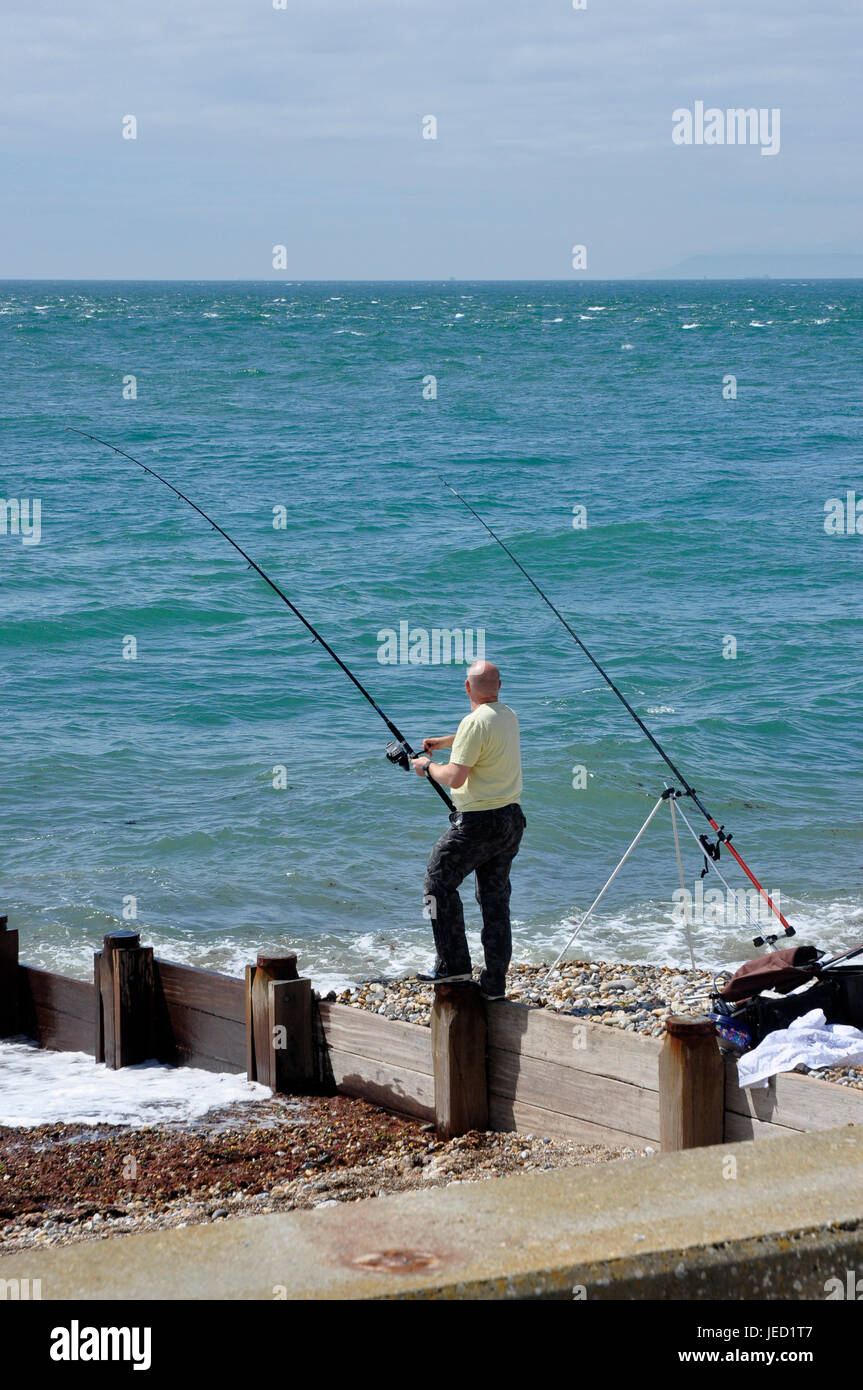 Strand Meer Angeln - Dorset - Fischer Kokons in Fang - blauen Himmel und Meer - Sonne - Wellenbrecher - Küste Wellen Stockfoto