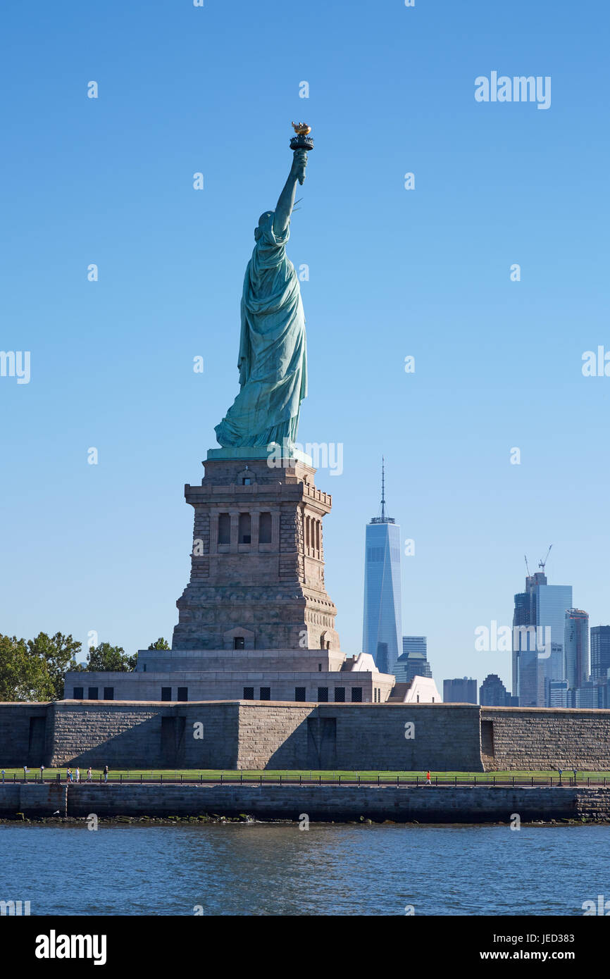 Statue von Liberty Island und New York City Skyline an einem sonnigen Tag, blauer Himmel Stockfoto