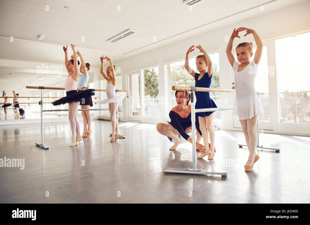 Lehrerin üben mit kleinen Ballerina in Gruppe im Ballett Klasse. Stockfoto