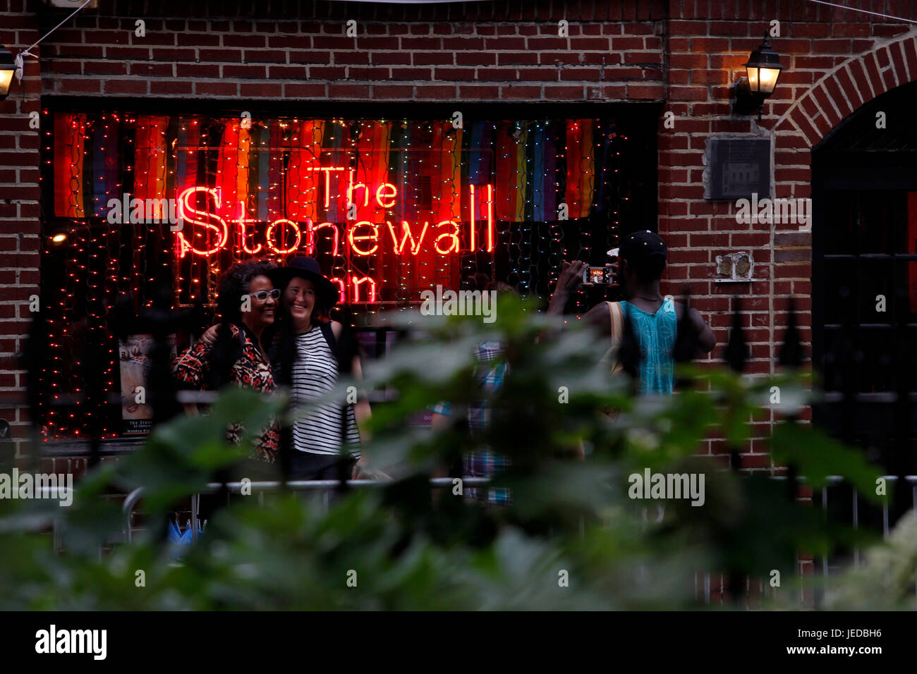 New York, USA. 23. Juni 2017. Das Stonewall Inn in New Yorks Greenwich Village, wo die Gay-Pride-Bewegung nach einer Serie von Demonstrationen in Beantwortung einer Razzia von der Bar im Jahr 1969 geboren.  Menschen sind auf der Website, jetzt ein nationales Denkmal, Beflockung, wie Gay-Pride-Veranstaltungen im Gange an diesem Wochenende auch am Sonntag-Pride-Parade in New York City bekommen. Bildnachweis: Adam Stoltman/Alamy Live-Nachrichten Stockfoto