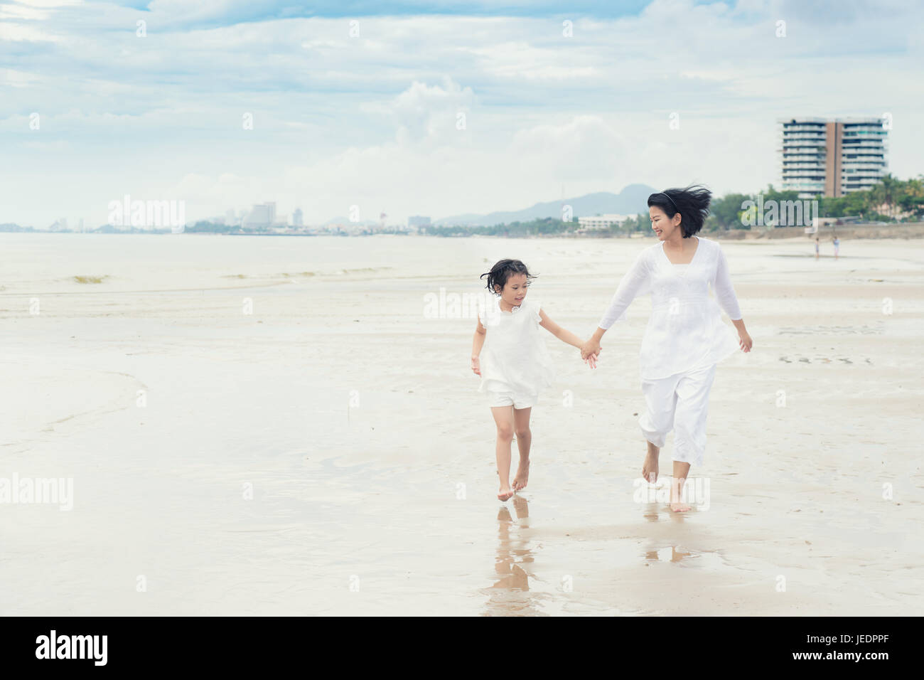 Glückliche asiatischen Familie Mutter und Kind Tochter laufen, lachen und spielen am Strand. Glückliche Familien-Sommer-Urlaub-Konzept. Stockfoto