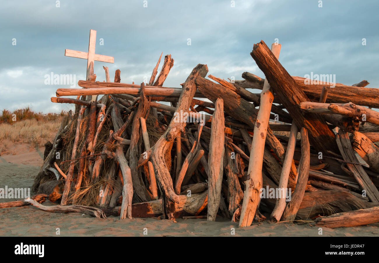 Weisses Kreuz auf einem Stapel von Strandholz. Stockfoto