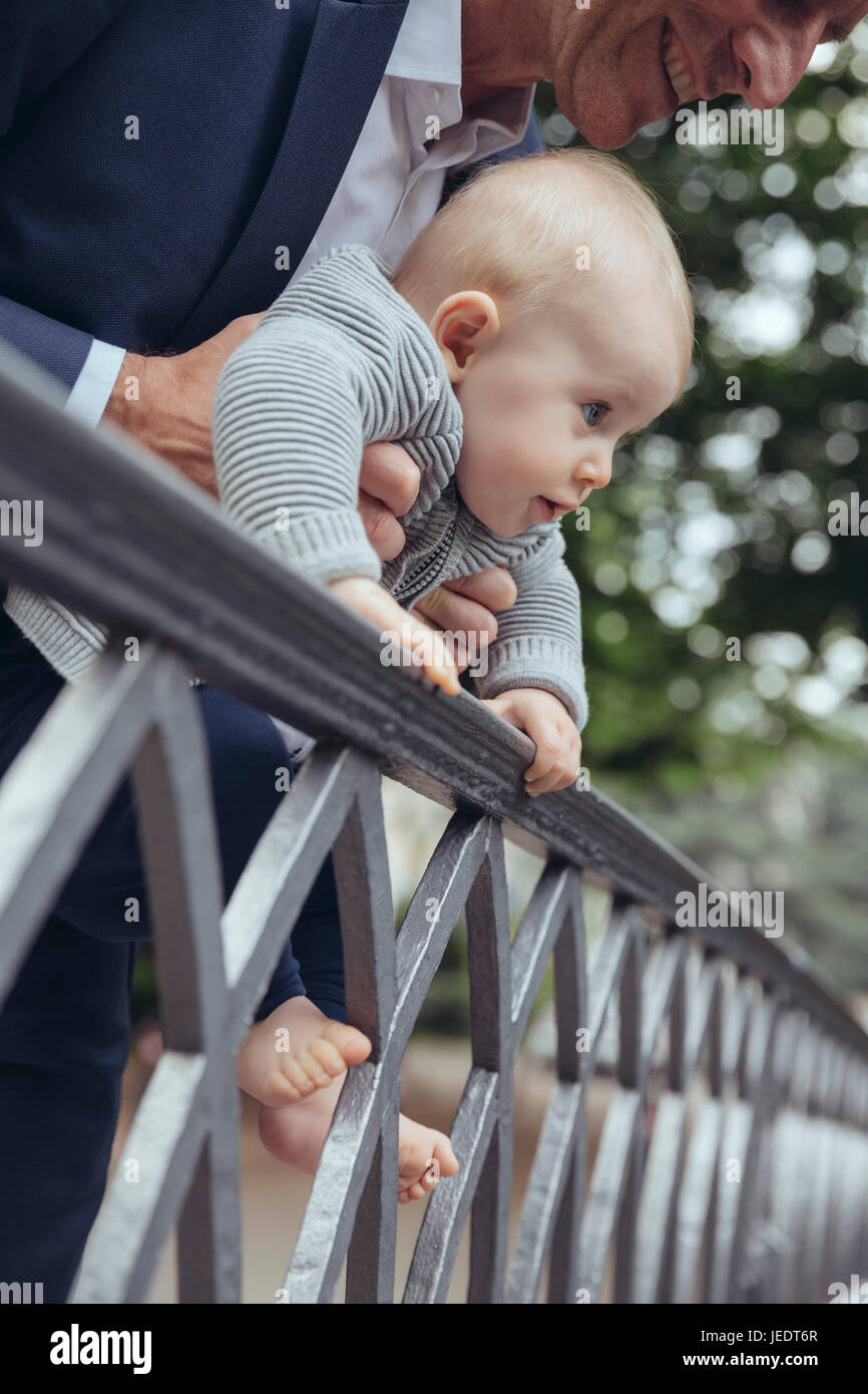 Vater mit seinem Baby, über einen Zaun zu schauen Stockfoto