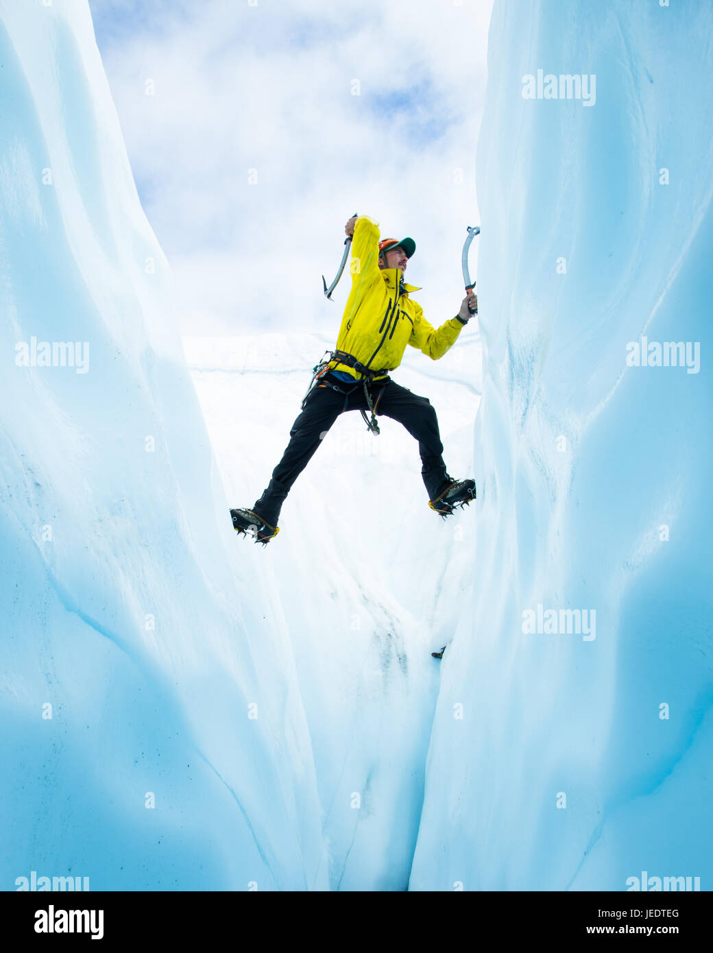 Eiskletterer klettern aus einer Gletscherspalte auf dem Matanuska Gletscher in Alaska. Er ist Solo Sie die Spanne und Eindämmung von beiden Seiten des Risses im Eis. Stockfoto