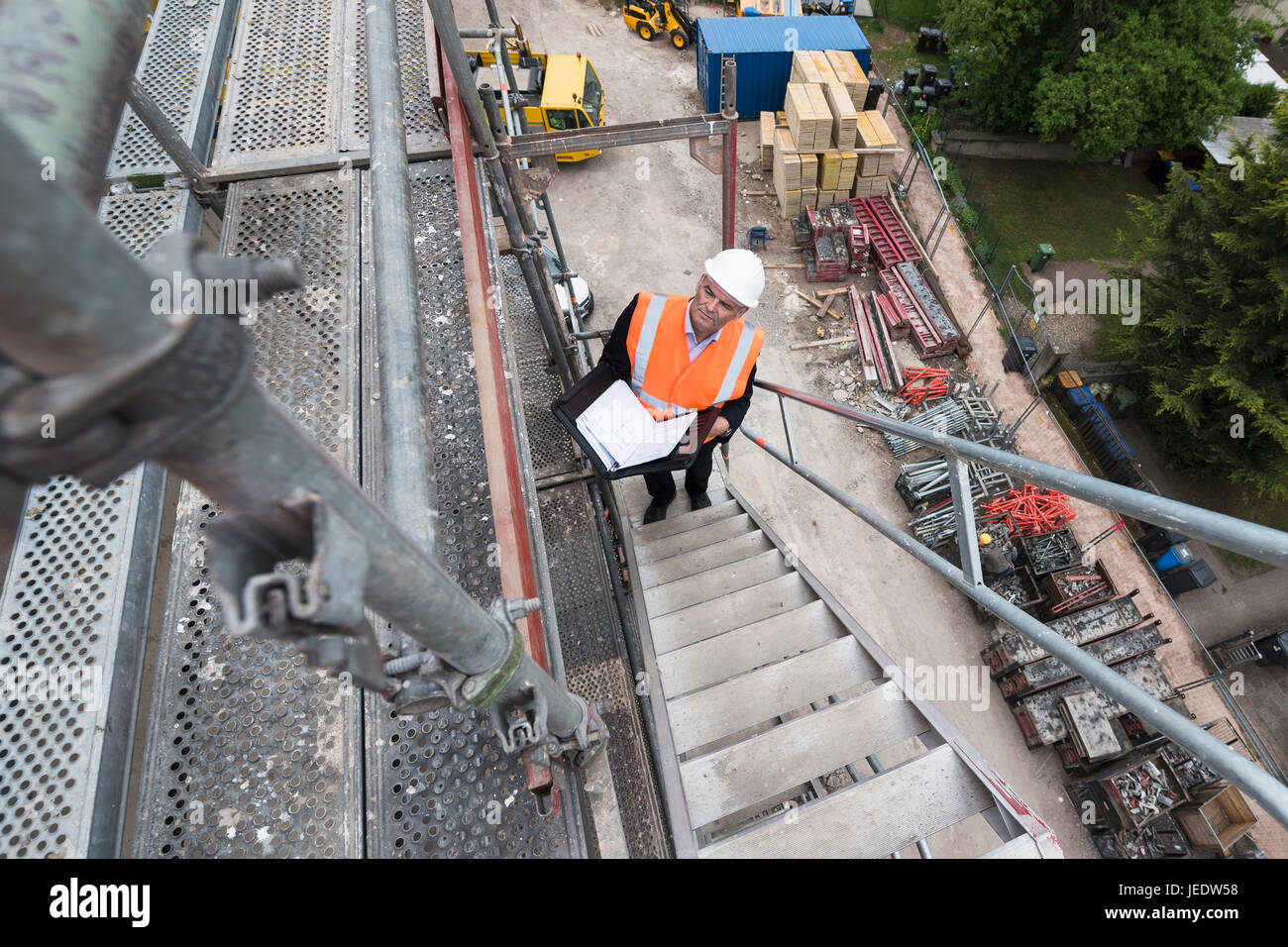 Mann mit Warnweste auf Gerüsten auf Baustelle Stockfoto