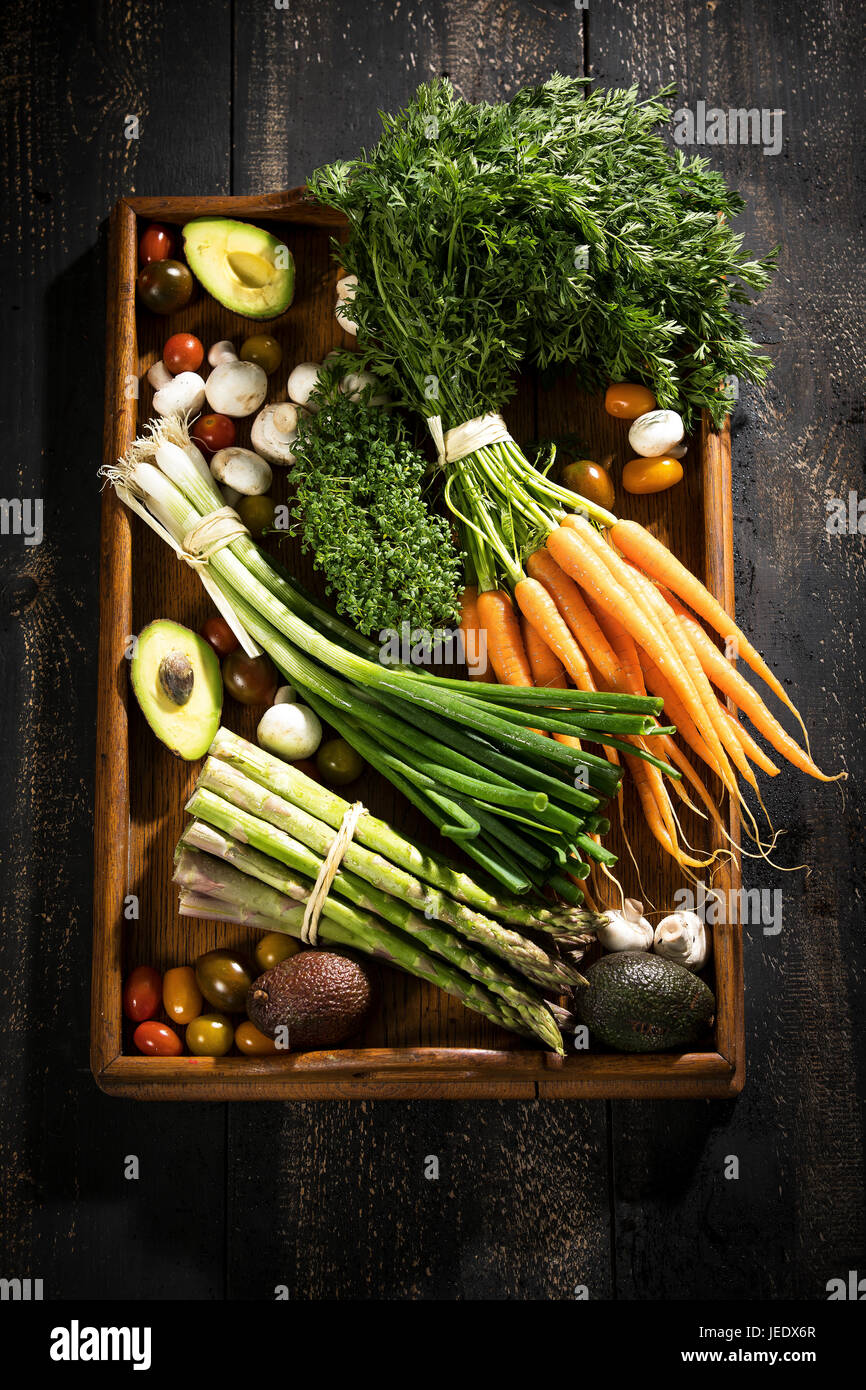 Verschiedene Bio-Gemüse auf dunklen Holztablett Stockfoto