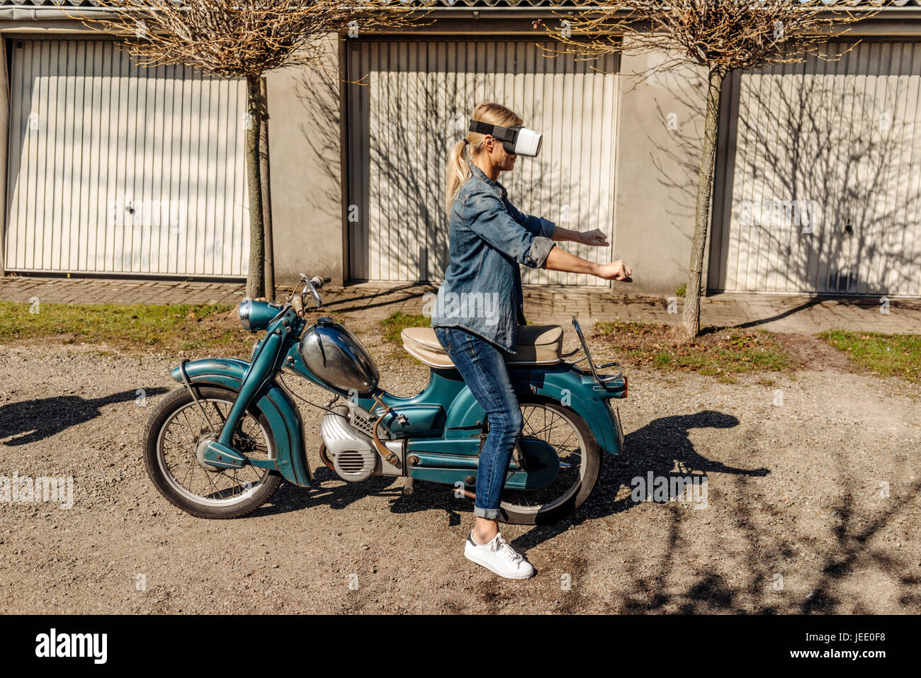 Frau mit Oldtimer Motorrad mit VR-Brille Stockfoto