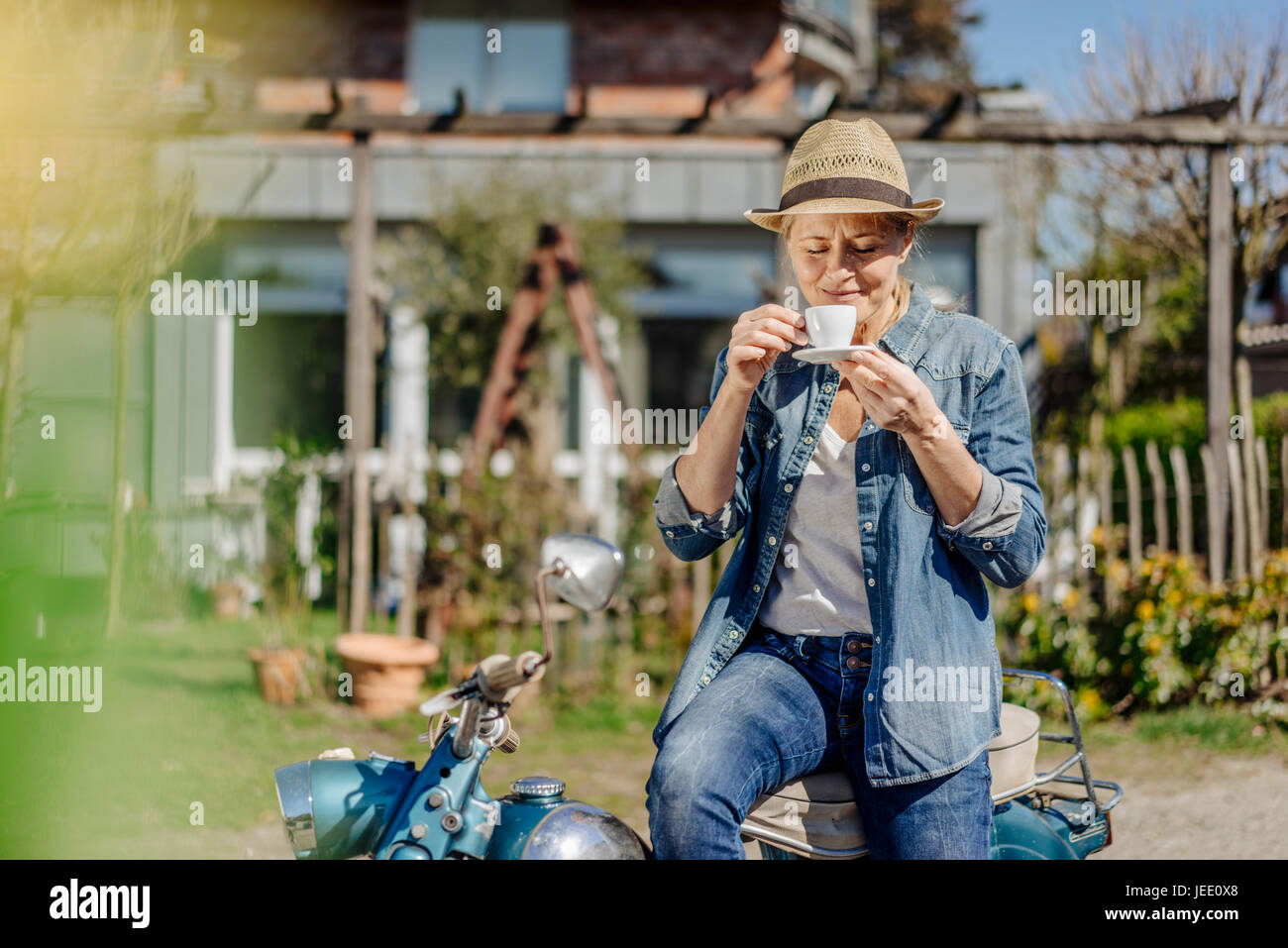 Frau auf Oldtimer Motorrad genießen eine Kaffeepause Stockfoto