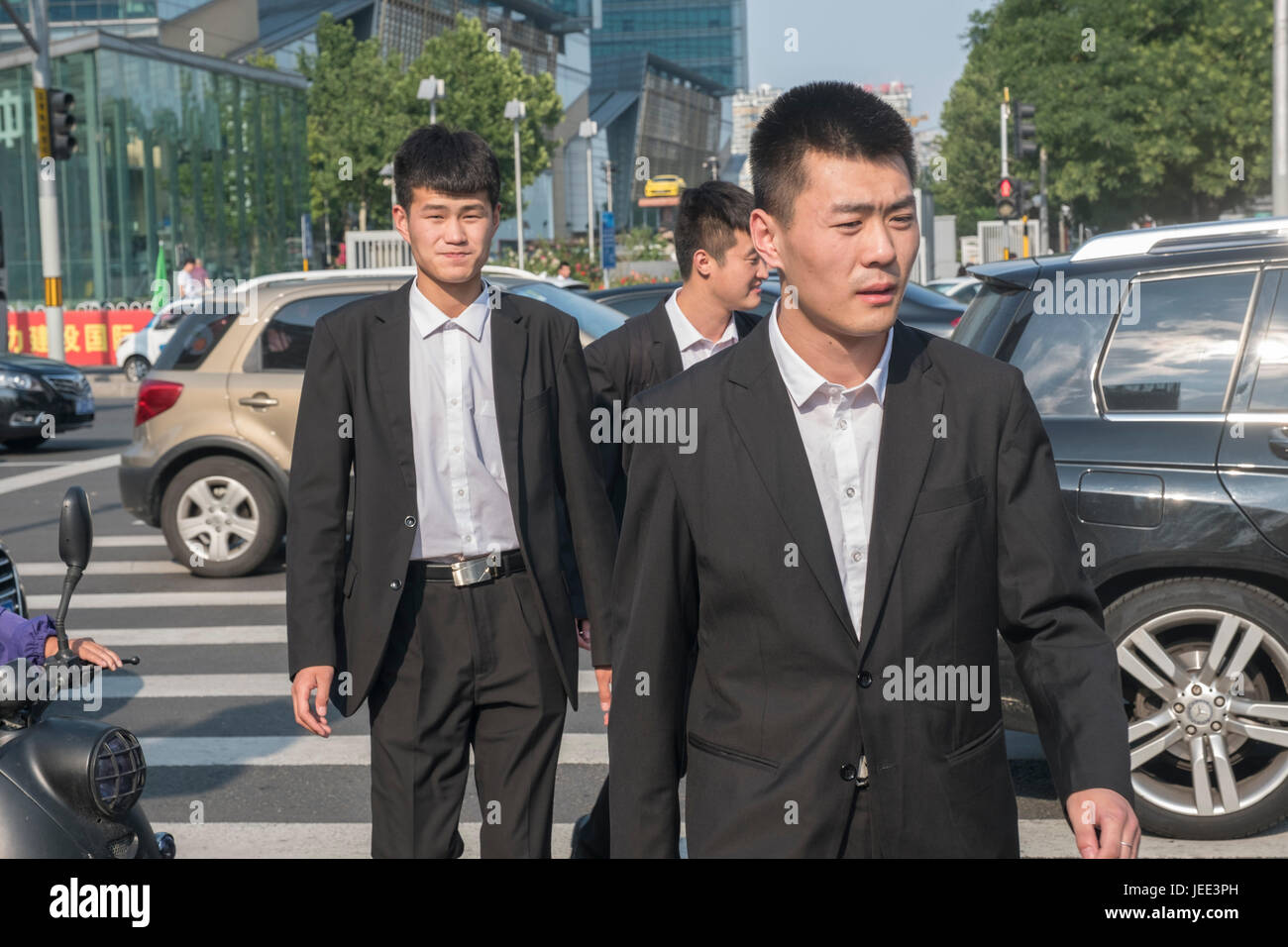 Chinesische Männer tragen Anzüge auf der Straße in Peking, China. Stockfoto