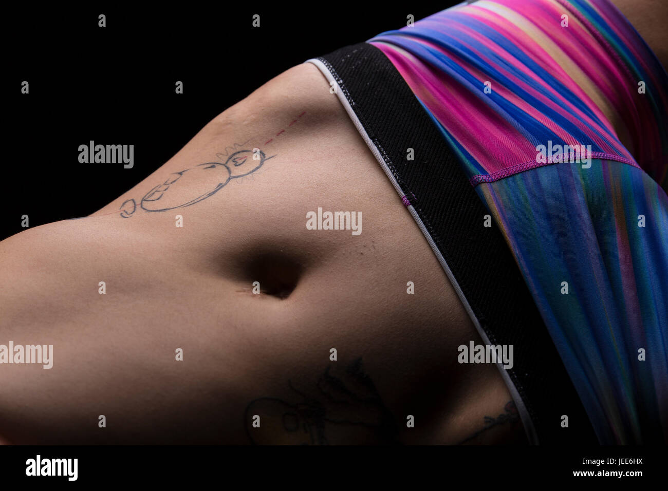 Nahaufnahme von Bauch und Hüften eine athletische junge Asiatin mit tattoos Stockfoto