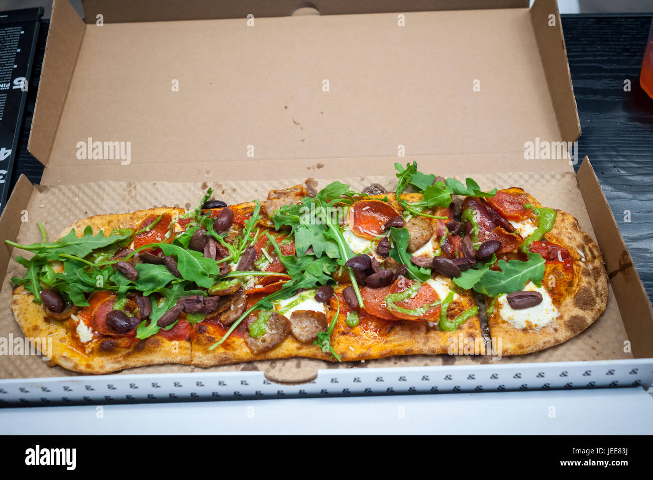 Maverick Pizza auf Eröffnung Tag der & Pizza, ihre erste New York Pizzeria am Dienstag, 20. Juni 2017. & Pizza baut seine Pizzen in gewissem Sinne Chipotle Stil mit dem Belag auf catering für Kunden individuelle Präferenzen setzen. Die 22 Ladenkette, vor allem im Bereich Washington DC bezeichnet sich selbst in einem Anti-Establishment-Restaurant mit länglich geformten kreative Kuchen, einige lokal bezogen, Zutaten und einem Hipster-Vibe mit "&" Mitarbeiter namens "Tribe" tätowiert.  (© Richard B. Levine) Stockfoto