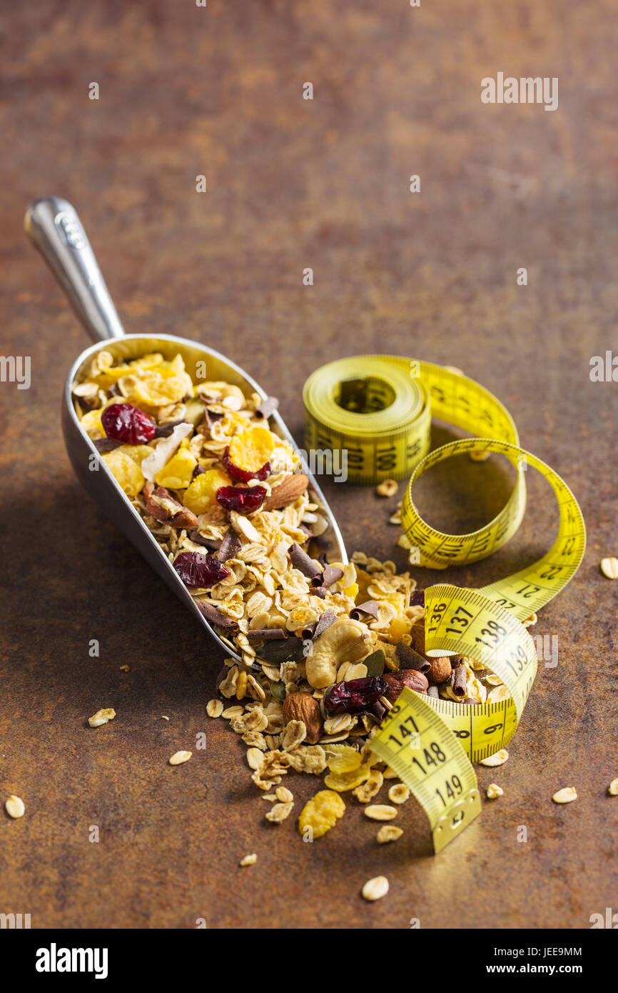 Leckeres, hausgemachtes Müsli mit Nüssen und Maßband. Diät-Konzept. Stockfoto