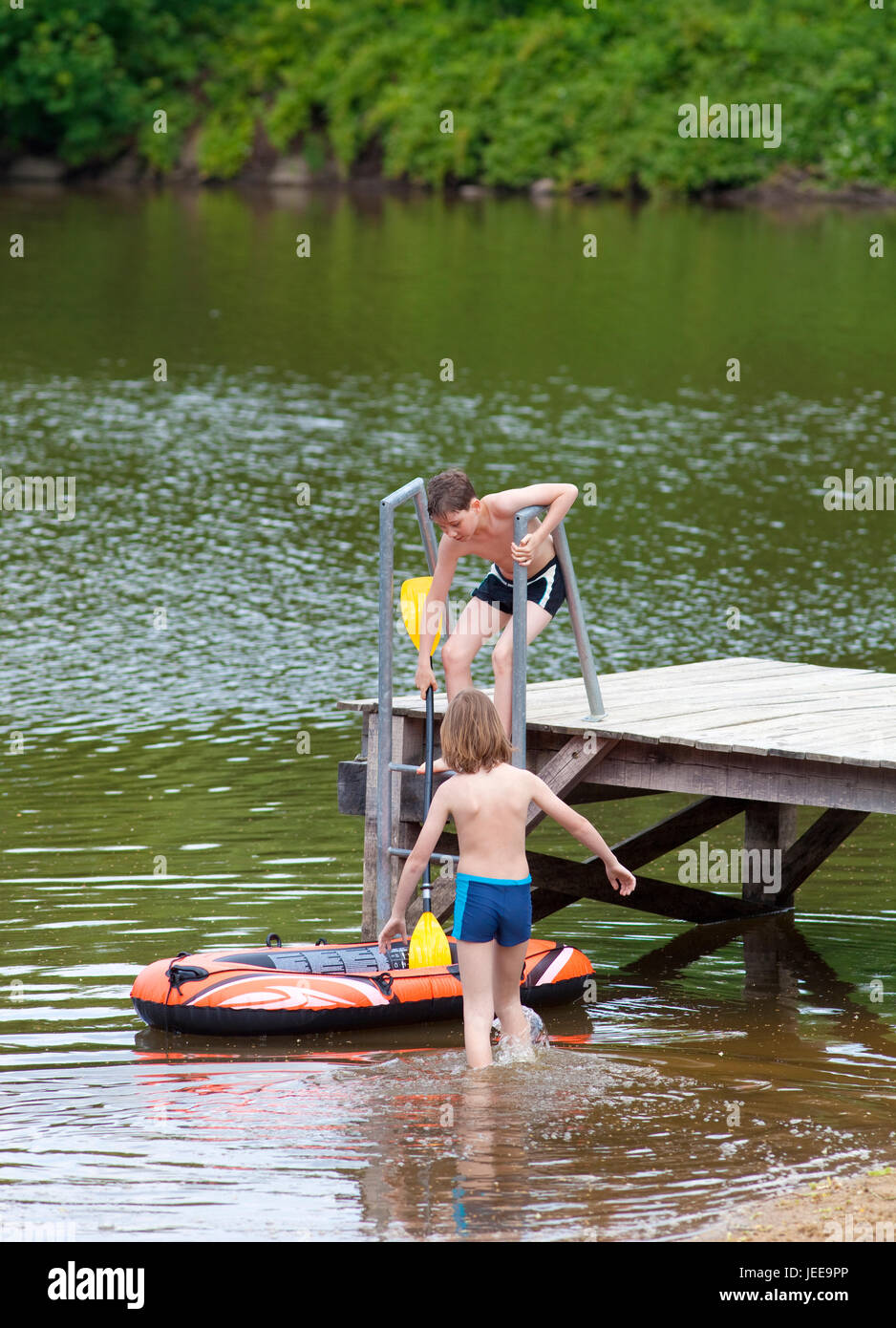 Zwei Jungs, die Spaß mit aufblasbaren Schlauchboot im Sommer Stockfoto