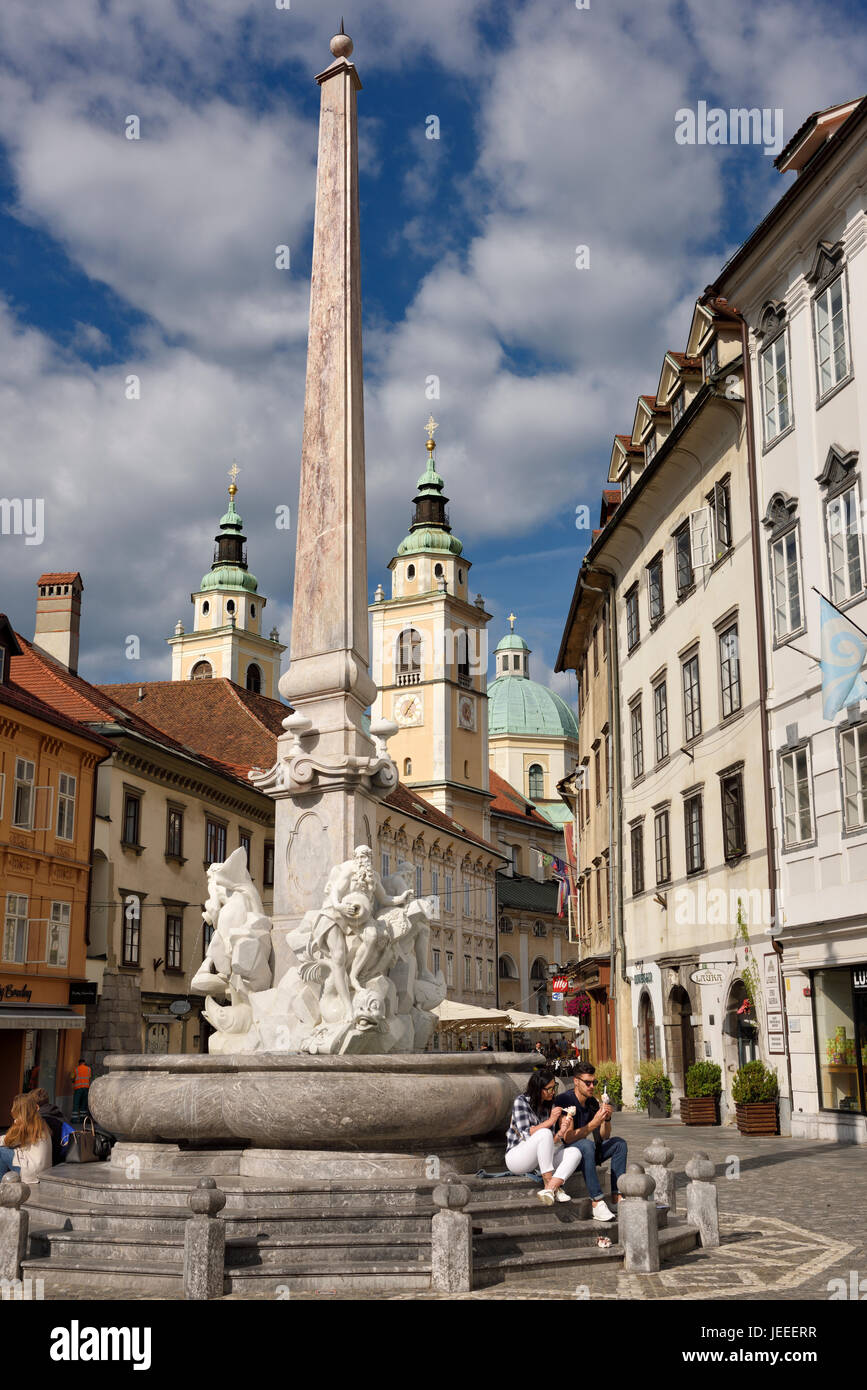 Touristen am Robba Brunnen der drei Flüsse in das Quadrat von Ljubljana Hauptstadt von Slowenien mit St. Nikolaus Kirche Kathedrale Stockfoto