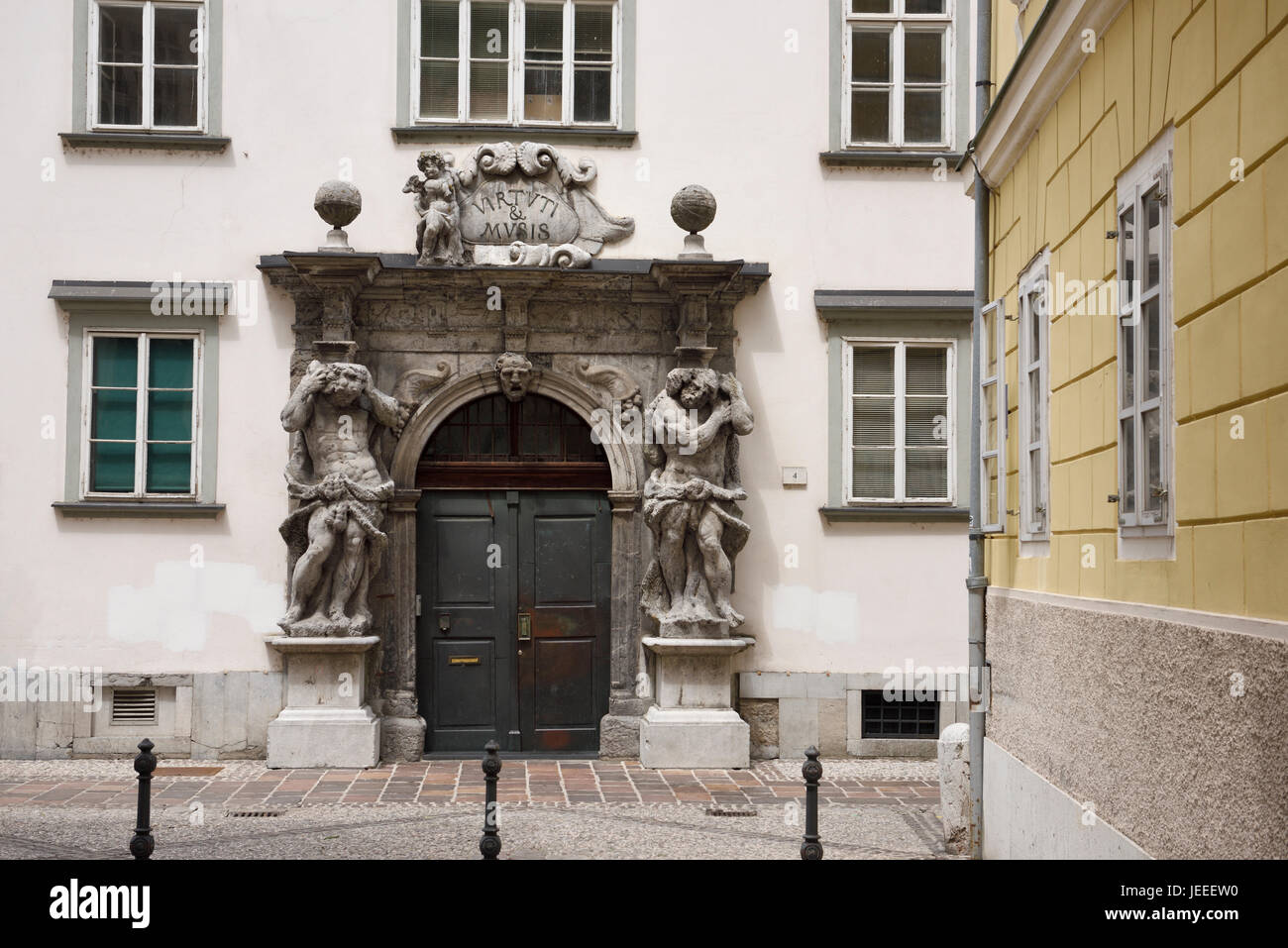 Eingang zum Ljubljana theologische Seminar Palast Bibliothek mit zwei Skulpturen von Atlas flankieren die Tür mit Motto Virtuti & Musis Slowenien Stockfoto