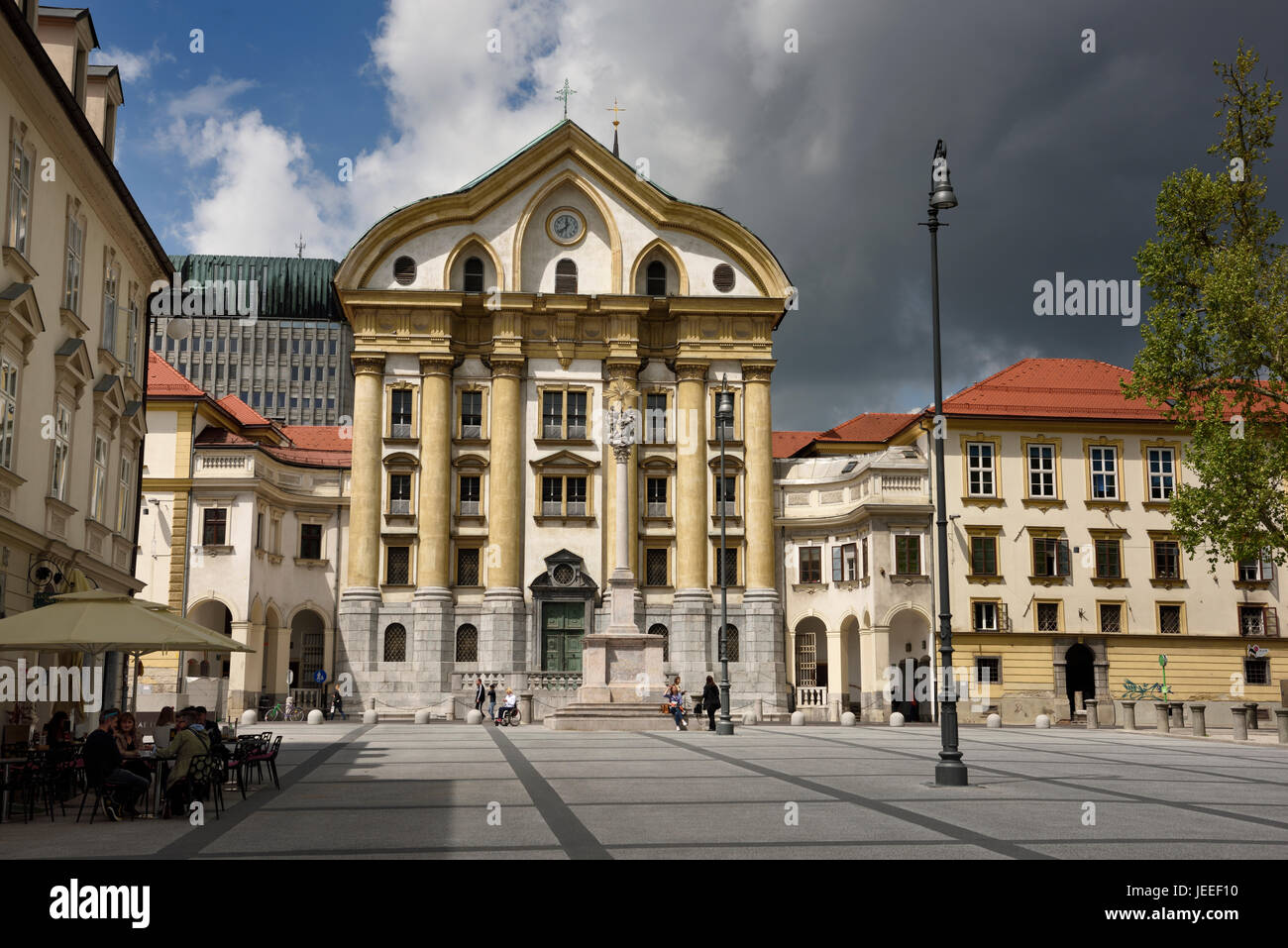 Ursulinen-Kirche der Heiligen Dreifaltigkeit mit Marmor-Statuen der Heiligen Dreifaltigkeit Spalte am Kongressplatz in Ljubljana Slowenien mit dunklen Wolken Stockfoto