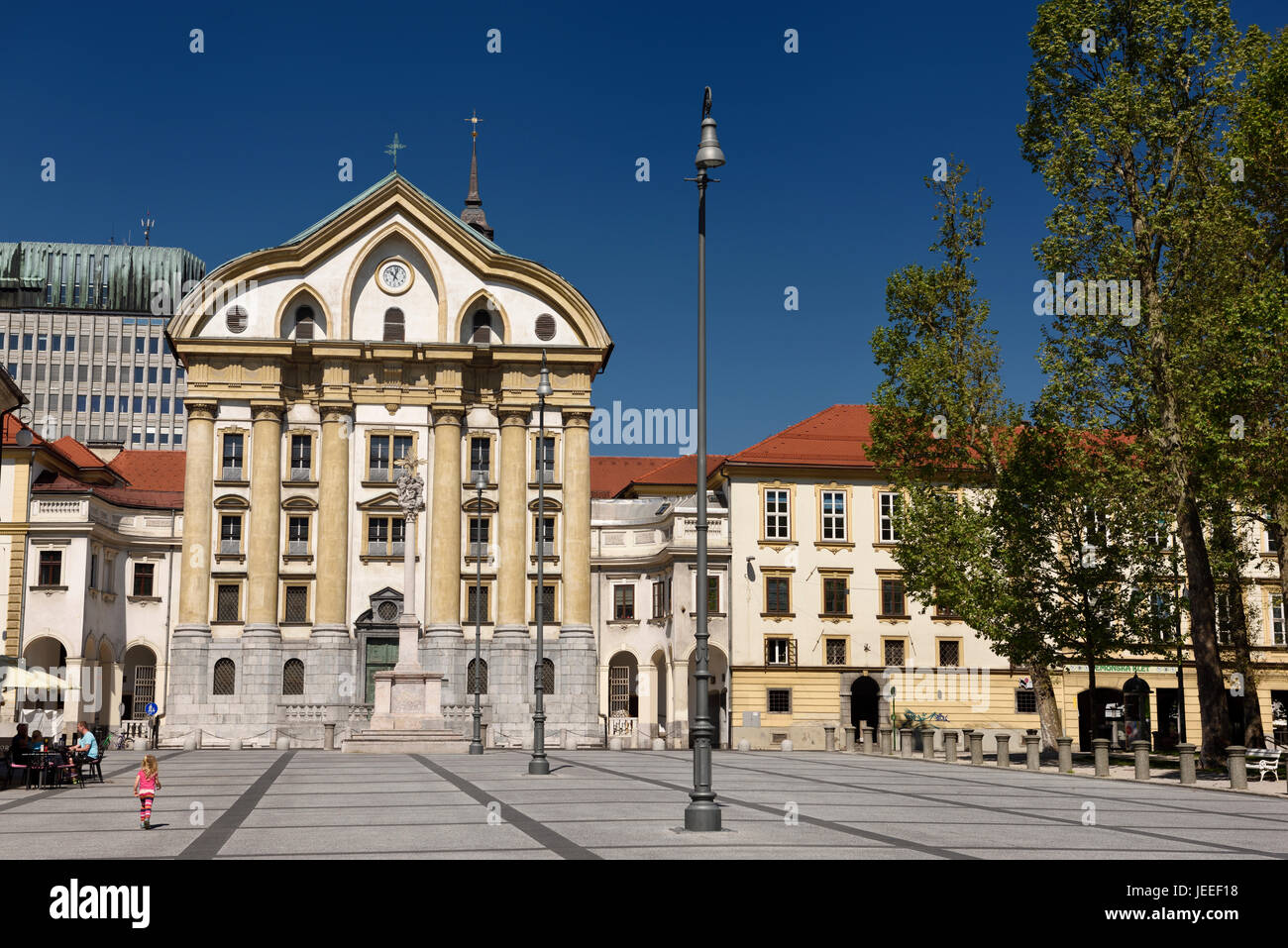 Blauer Himmel und rosa Mädchen Kongressplatz mit Ursulinen-Kirche der Heiligen Dreifaltigkeit mit Marmor-Statuen der Heiligen Dreifaltigkeit Spalte in Ljubljana Slowenien Stockfoto