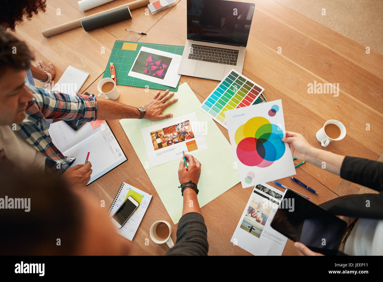 Draufsicht Schuss Gruppe von kreativen Designern diskutieren die Farbpalette bei treffen. Kreativ-Team um Tisch brainstorming. Stockfoto