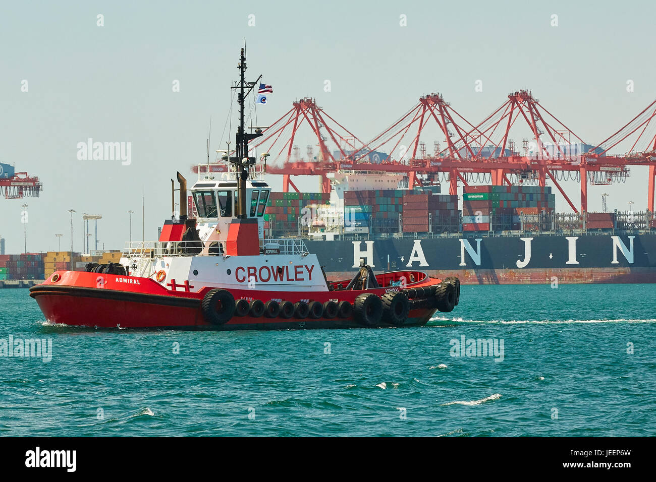 Crowley Maritime Traktor Schlepper im Long Beach Containerterminal mit einem riesigen Hanjin Container Schiff be- und Entladen hinter, Hafen von Long Beach. Stockfoto