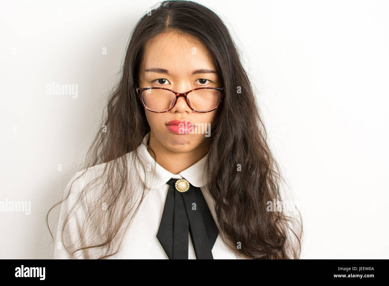 Müde, junge asiatische Geschäftsfrau mit Brille Stockfoto