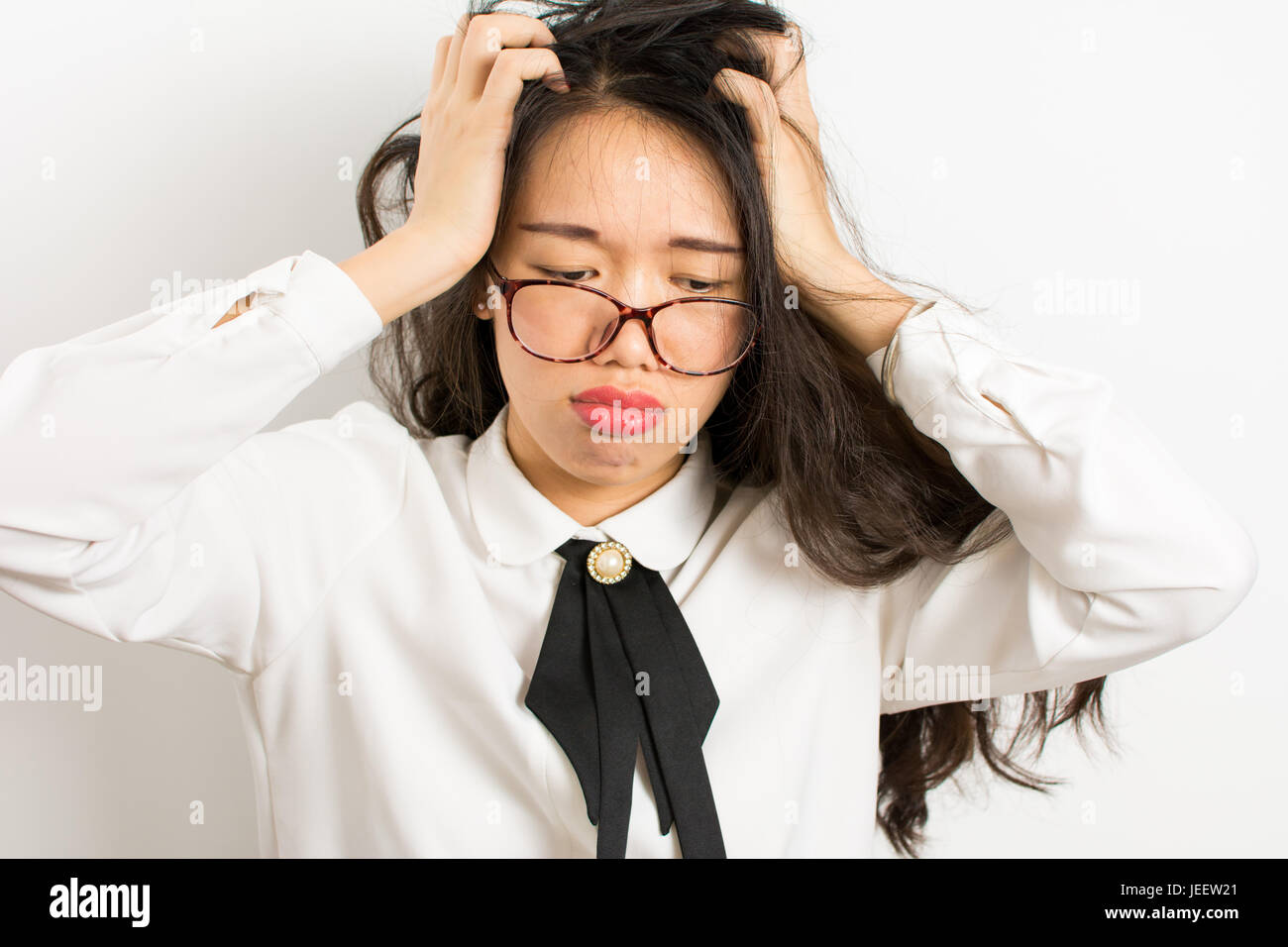 Müde, junge asiatische Geschäftsfrau mit Brille Stockfoto