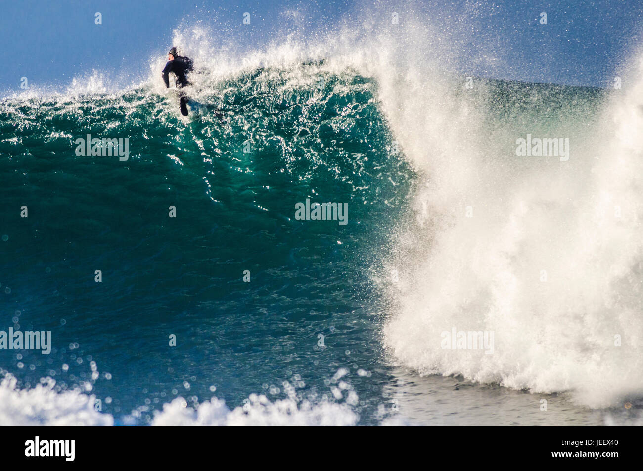 Tapferer Surfer, der über eine beängstigende brechende Welle paddelt Stockfoto
