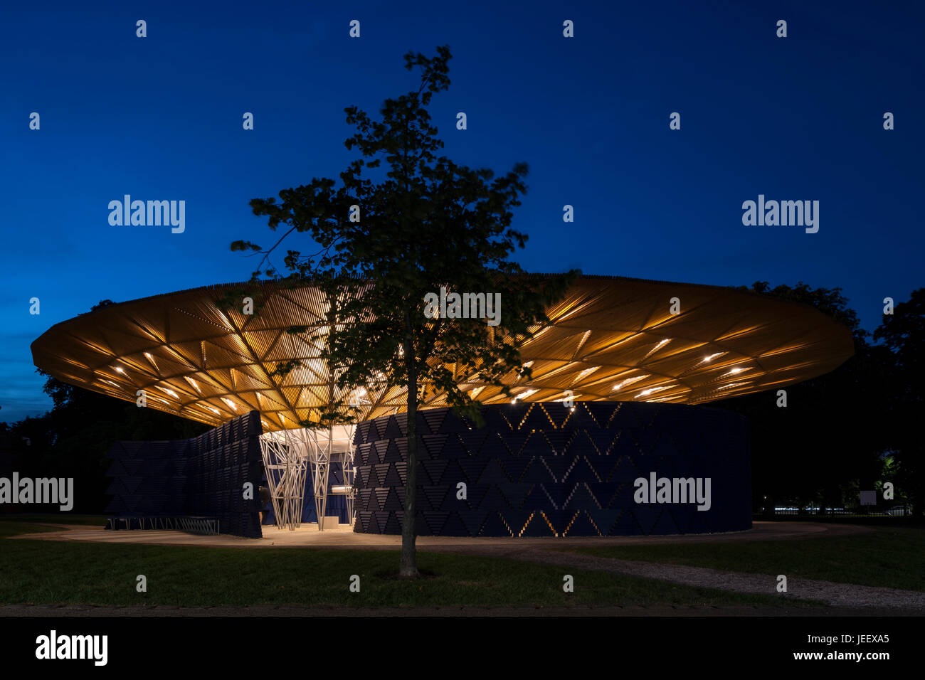 Zeigen Sie Nachtzeit mit Baum an. Serpentin Sommer Pavillon 2017, London, Vereinigtes Königreich. Architekt: Diebedo Francis Kéré, 2017. Stockfoto