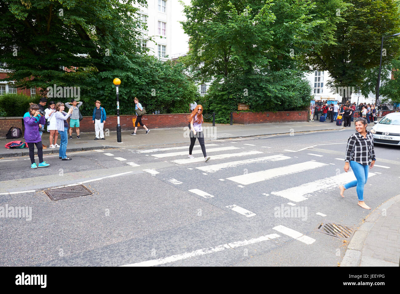 Touristen, die den Zebrastreifen überqueren berühmt geworden durch die Beatles außerhalb Abbey Road Studios, London, UK Stockfoto