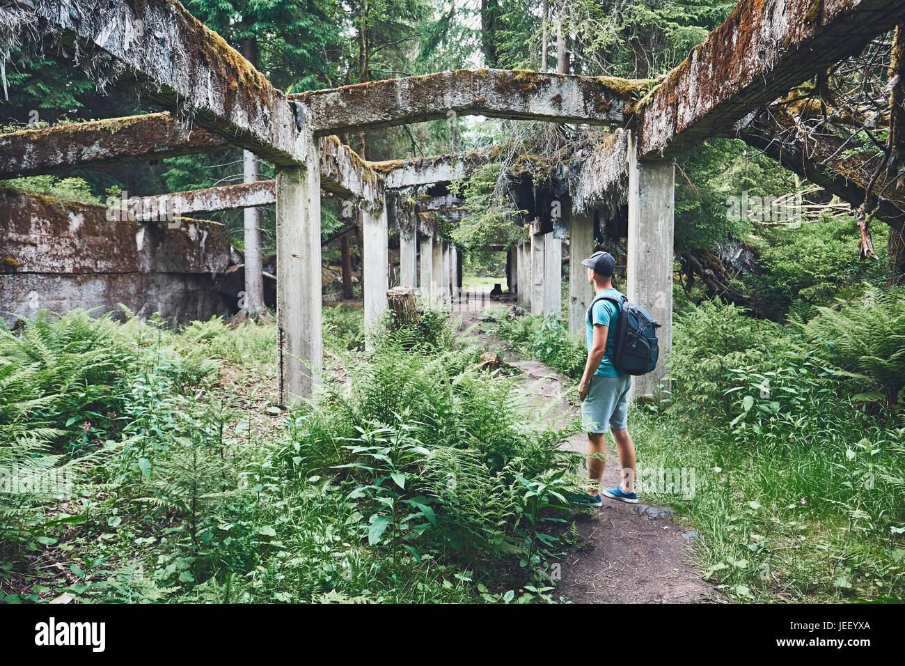 Jungen Entdecker im Inneren der verlassenen alten zerstörten Fabrik mitten im Wald. Erzgebirge, Tschechien Stockfoto