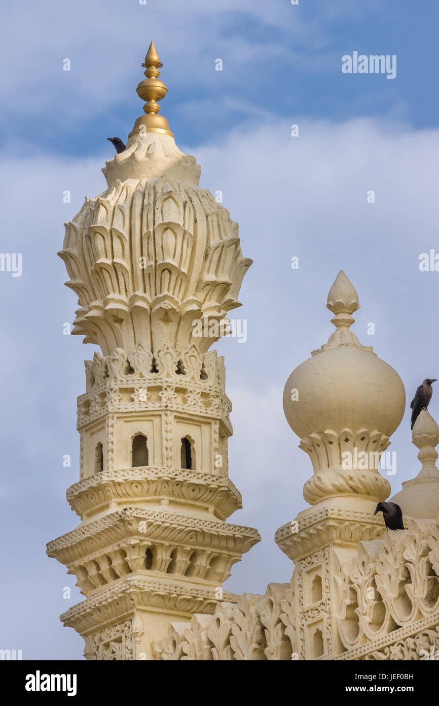 Mysore, Indien - 26. Oktober 2013: Creme gelb Stein Ecke Minarett der Oberkonstruktion Tipu Sultan Mausoleum mit schwarzen Vögel. Goldene Kalasam an der Spitze, Stockfoto