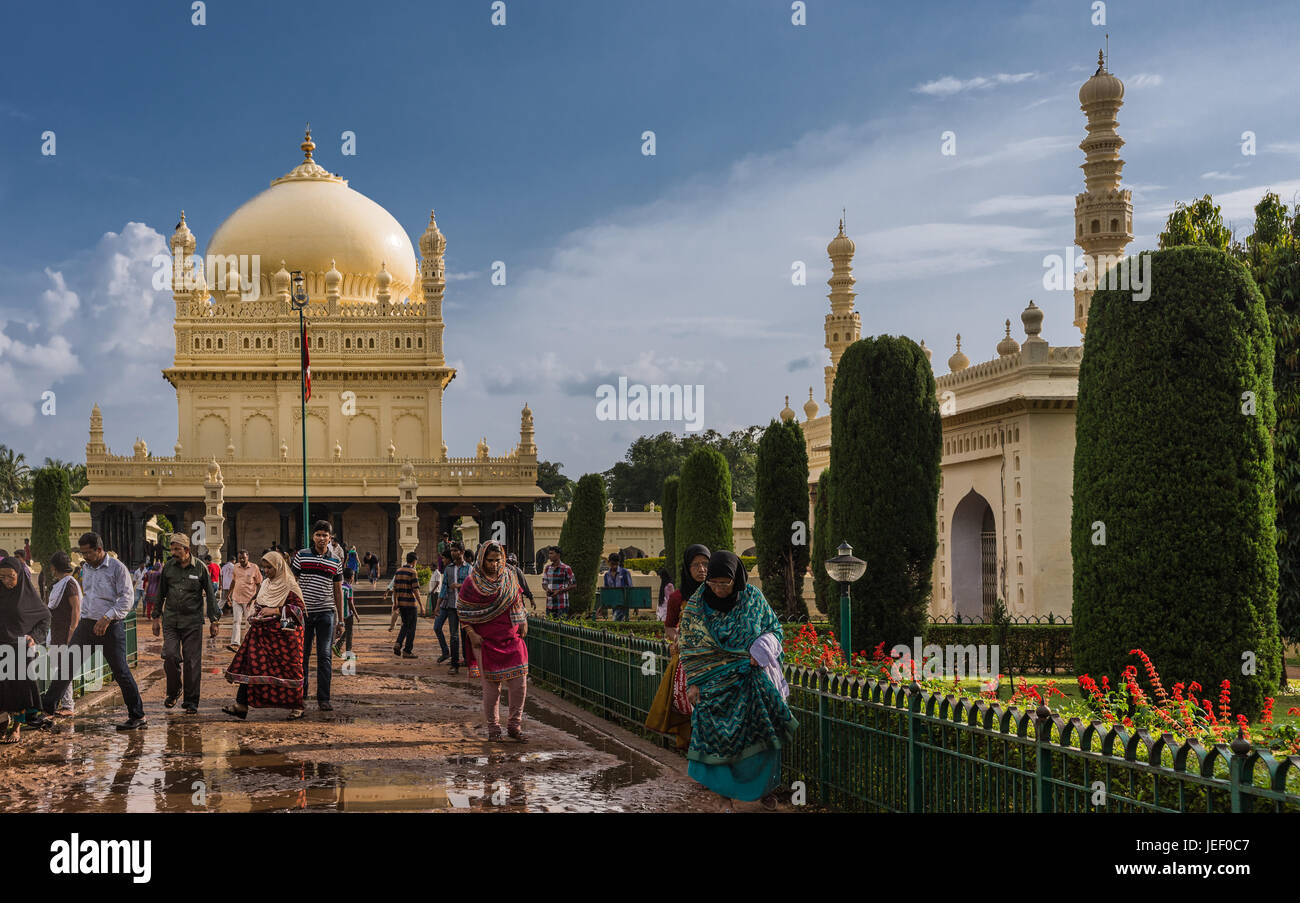 Mysore, Indien - 26. Oktober 2013: Creme gelb Tipu Sultan Mausoleum mit Kuppel und Moschee unter schweren Wolkengebilde. Menschen zu Fuß, und aus dem build Stockfoto