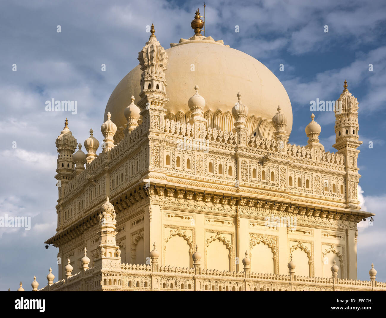 Mysore, Indien - 26. Oktober 2013: Obere Struktur und Kuppel der Creme gelb Tipu Sultan Mausoleum unter blauen Wolkenhimmel. Goldene Kalasam an der Spitze. Stockfoto