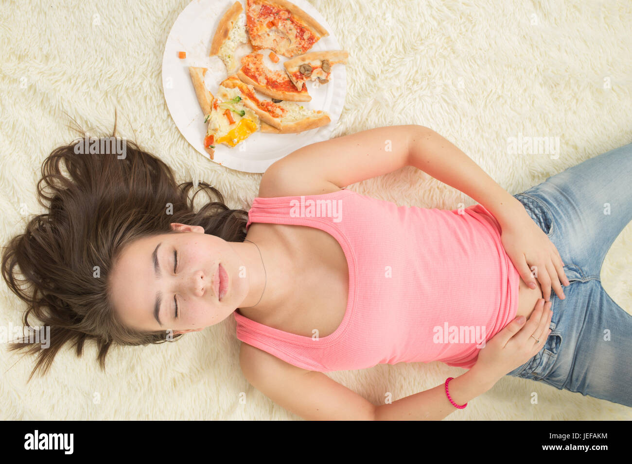 Essen Sie, unglückliche Frau mit Stücken von Pizza auf weißem Hintergrund Stockfoto