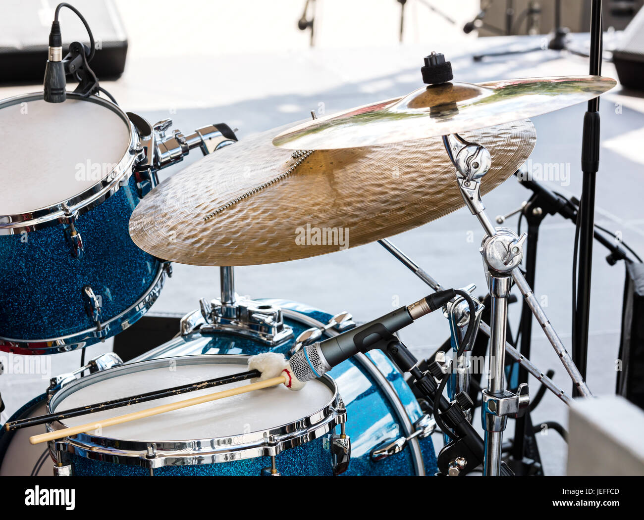 blaue Drumset mit zwei hölzernen Drumsticks drauf. Musikinstrumente auf der Bühne, bereit für den Auftritt. Stockfoto